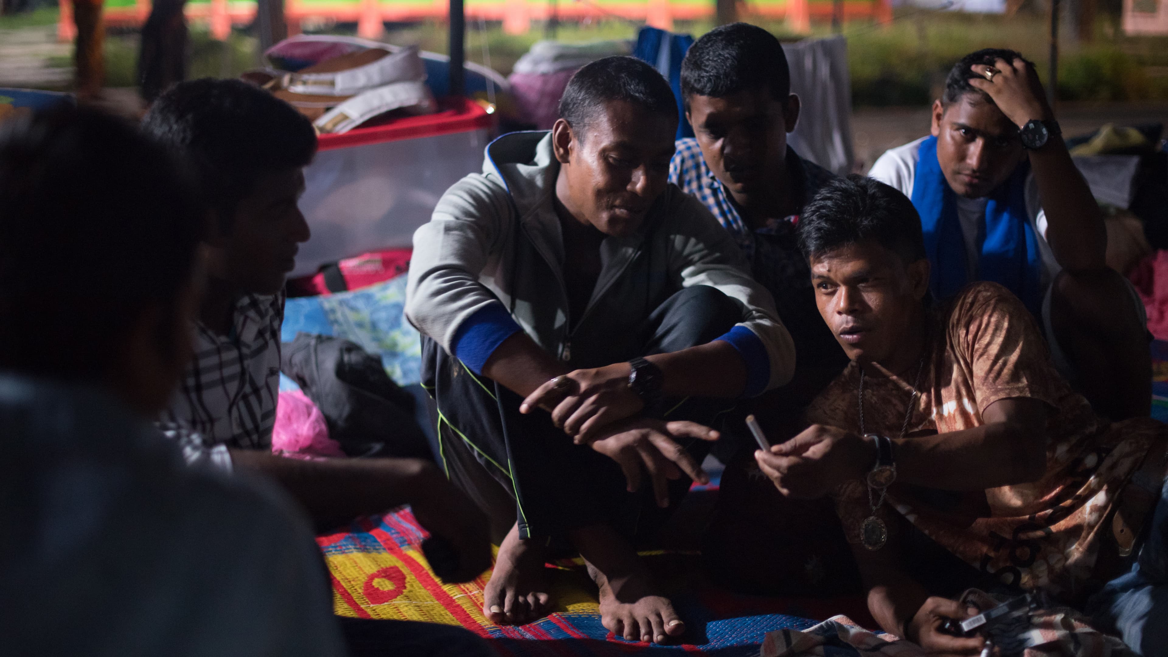 Taufik (bottom right) is a fisherman who saved the Rohingya and Bangladeshi from sea in May. Even though they aren’t real family, he says, he loves them and he feels a responsibility to take care of them. He visits the Bayeun, East Aceh, Indonesia refugee