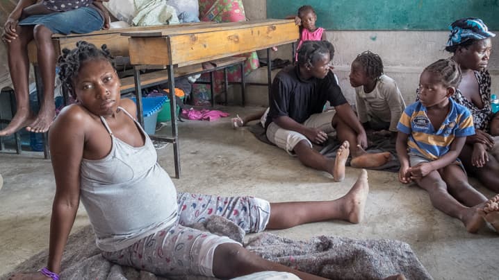 Women and children sit in a classroom at a school in Fond Parisen, Haiti. About 50 people of Haitian descent are staying at the school after being forced out of the Dominican Republic.