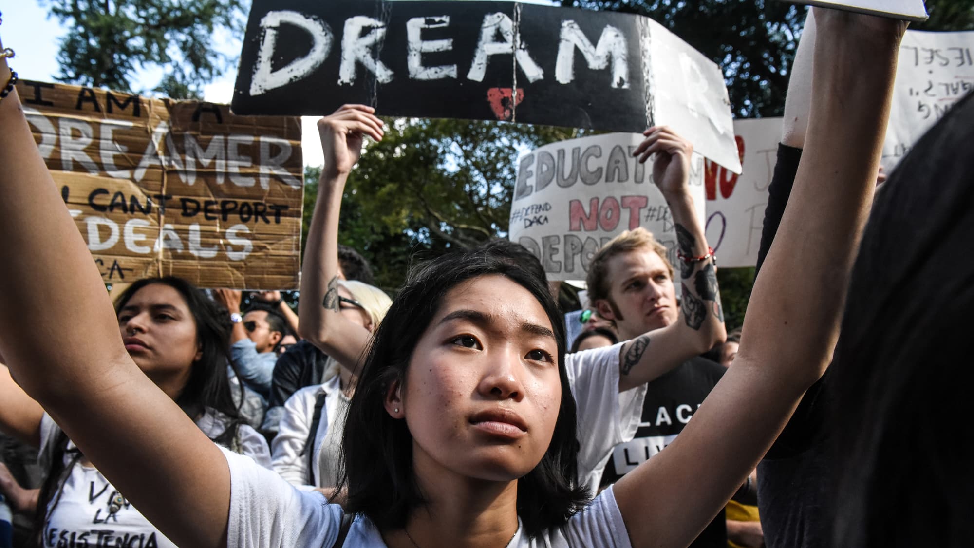 People participate DACA protest holding up signs with messages against deportation.