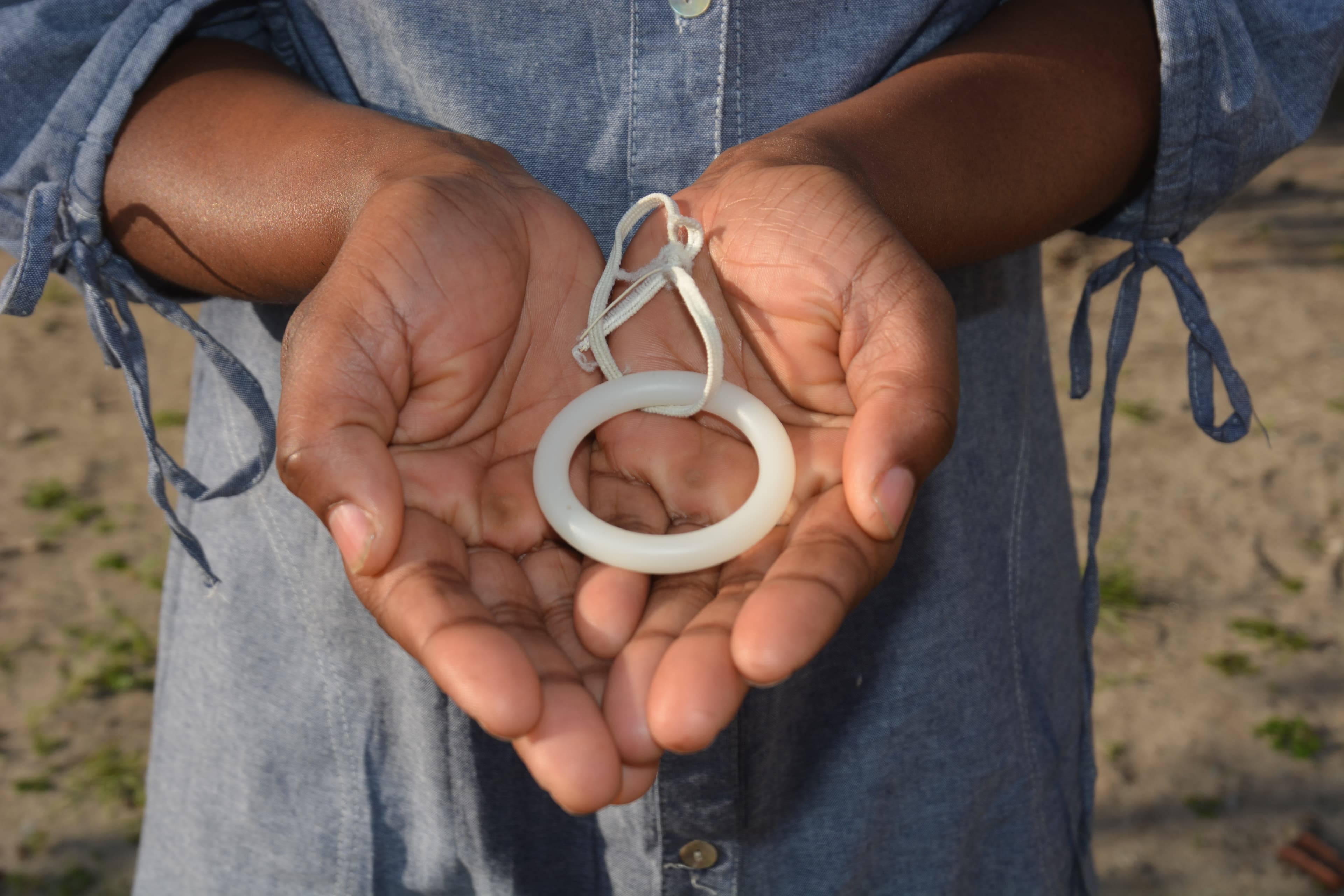 Close-up of woman holding white silicone vaginal ring