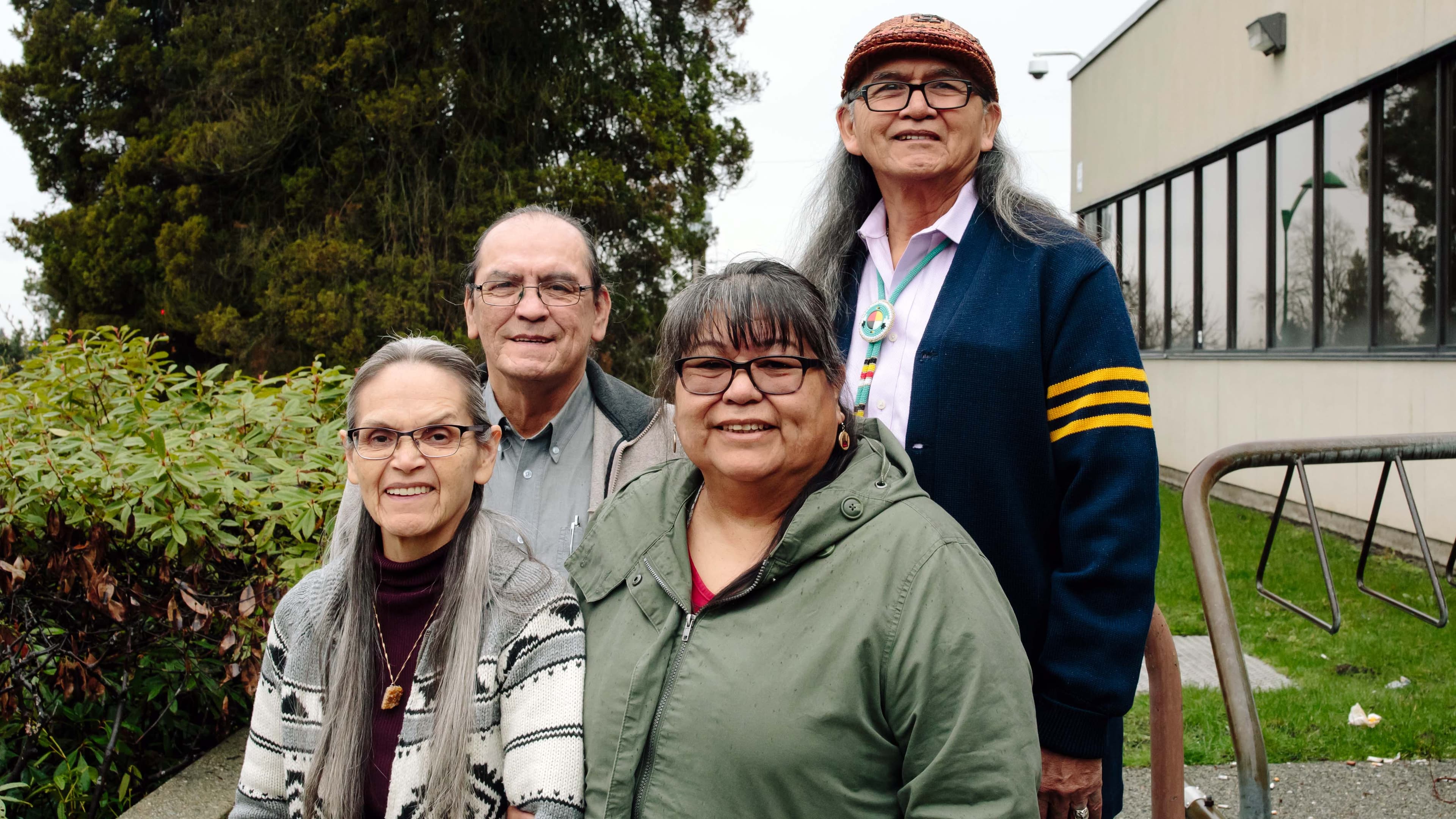 Two men and two women stand together next to a court house.