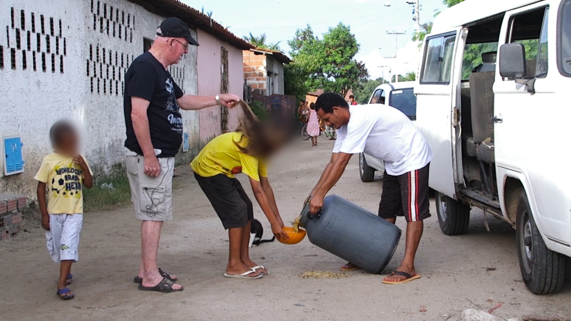 Accused child sex abuser Father Jan Van Dael plays with the hair of a boy collecting a soup donation, in a slum outside Caucaia, Brazil.