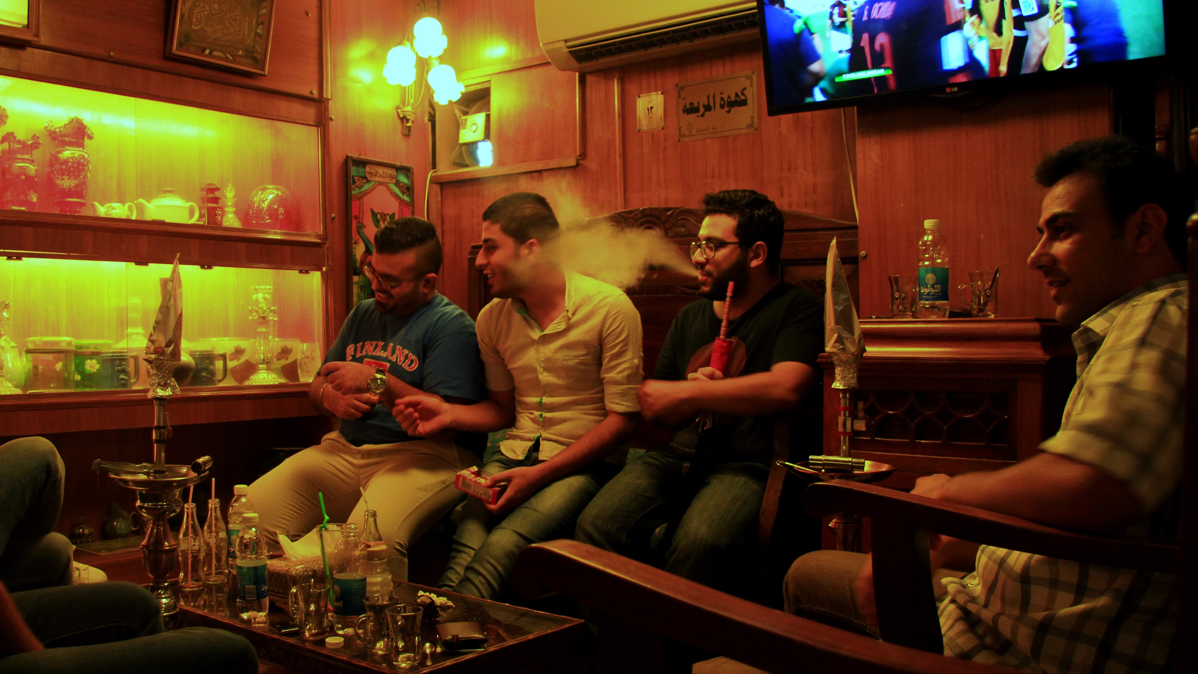 A table of young men at the Al Atrakchi House cafe in Baghdad's Mansour neighborhood. It's decorated with antique Iraqi furniture and artifacts. The owner says he's created this space to remind Iraqis of their country's rich history in hopes they'll be in
