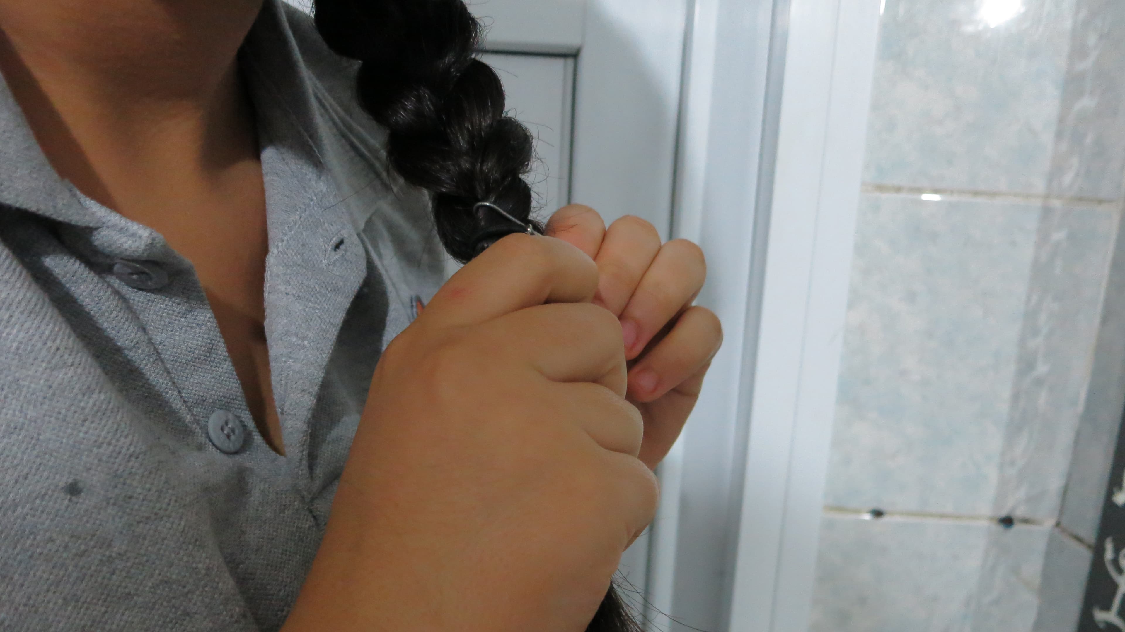 Fatma braids her hair before heading off on the two-hour ride to school. Her father's angry that school is 20 miles away and that Fatma must ride the public bus.