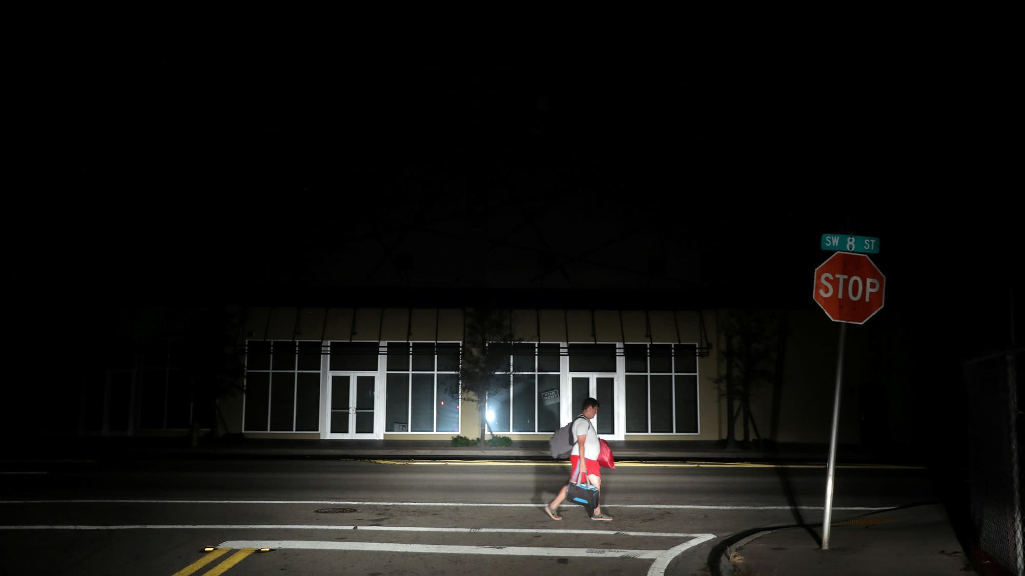 A man walks back home in the darkness as many areas of Miami still without electricity after Hurricane Irma plowed through the region.