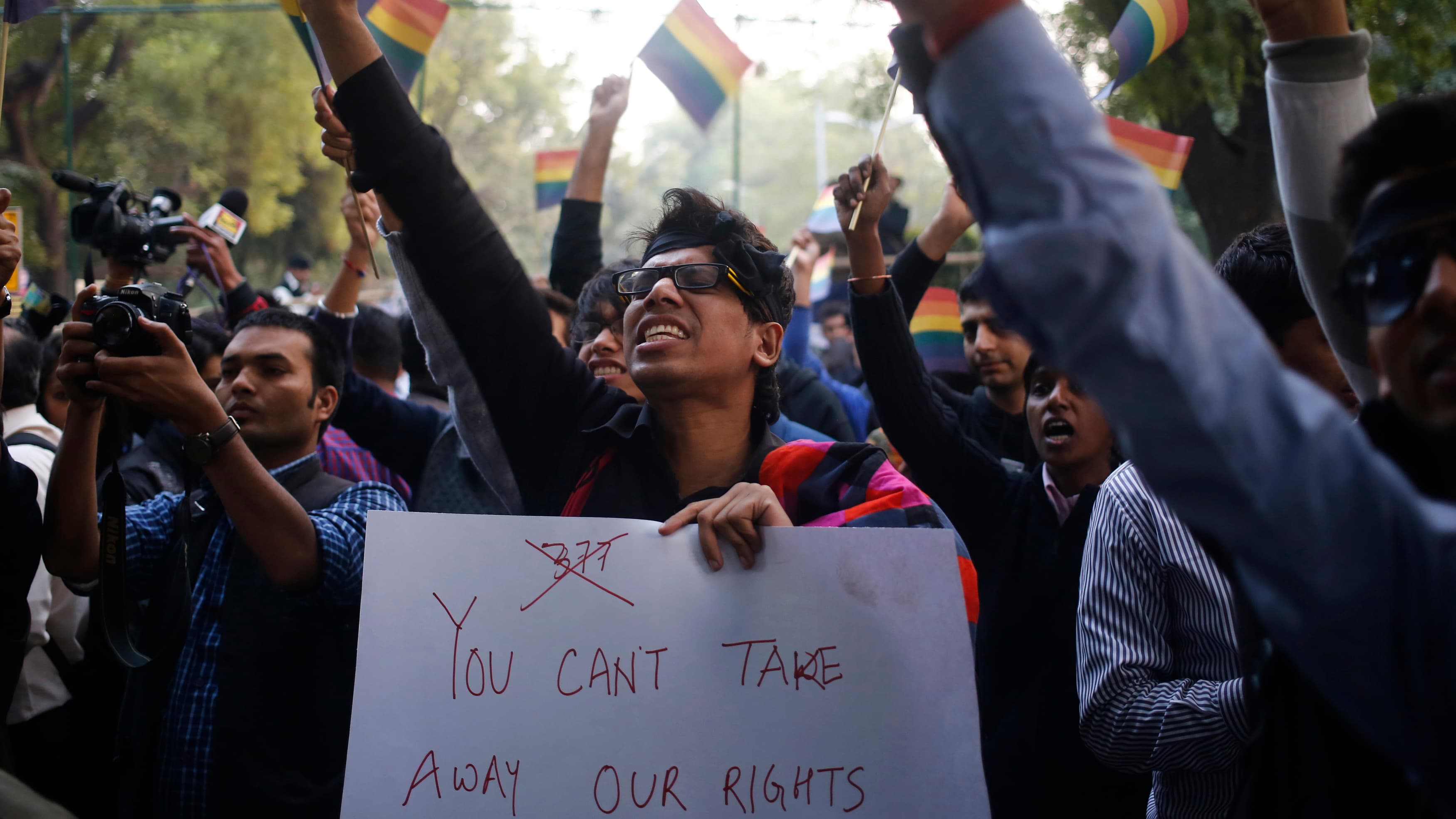 Gay rights activists wave flags and shout slogans as they attend a protest against a verdict by the Supreme Court in New Delhi December 11, 2013.