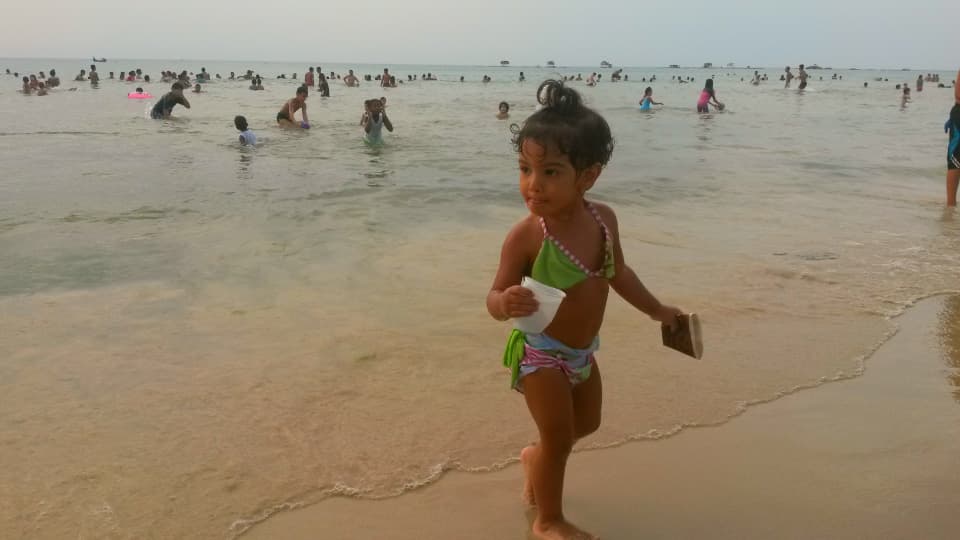 A young girl plays on the beach in Tripoli, Libya, where many people have turned to the waterfront to try and find relief from power cuts and political chaos.