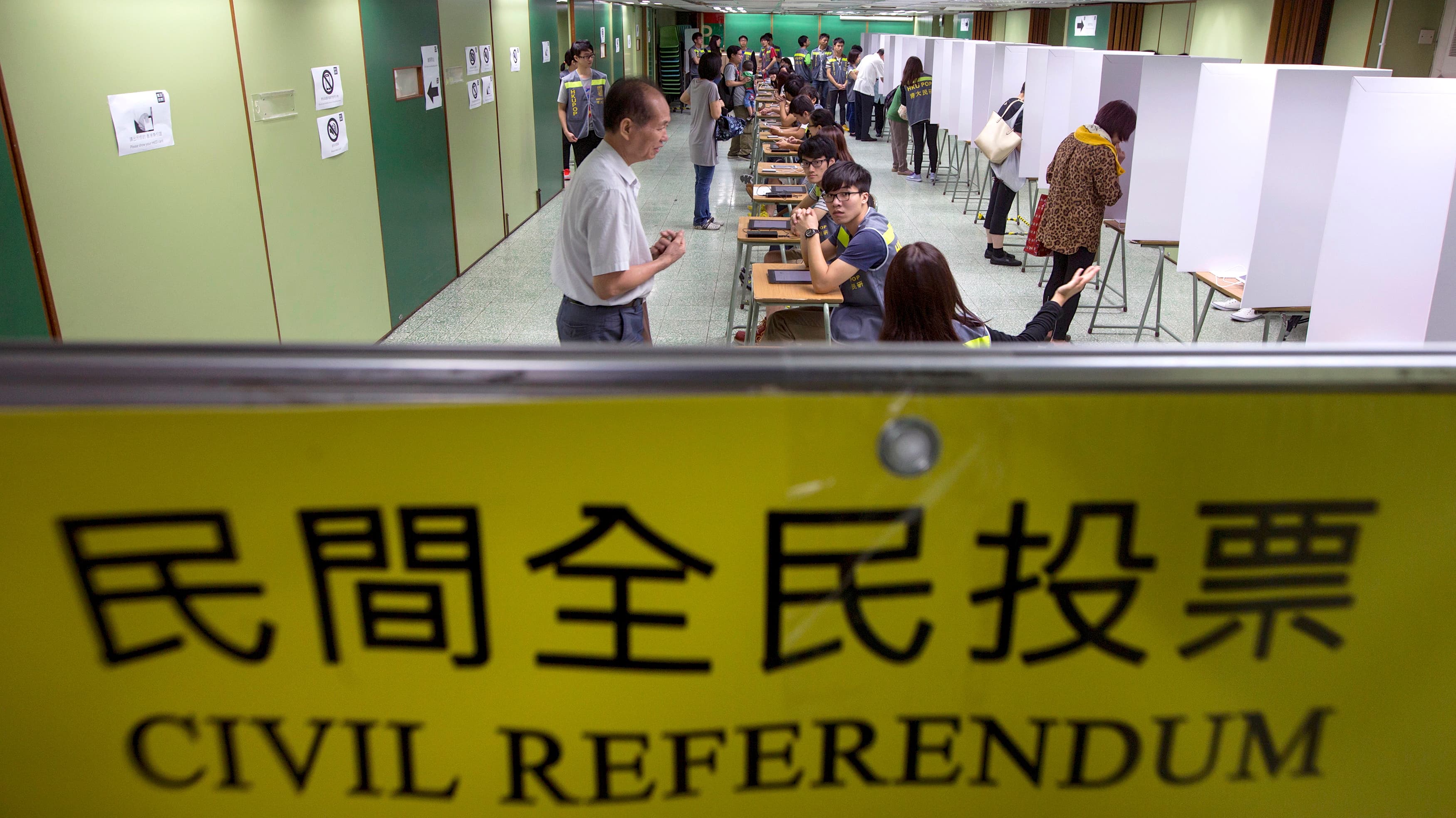 Voters are guided inside a polling station during a civil referendum held by a group in Hong Kong called “Occupy Central with Love and Peace.” The unofficial referendum sparked warnings from China's Communist Party leaders.