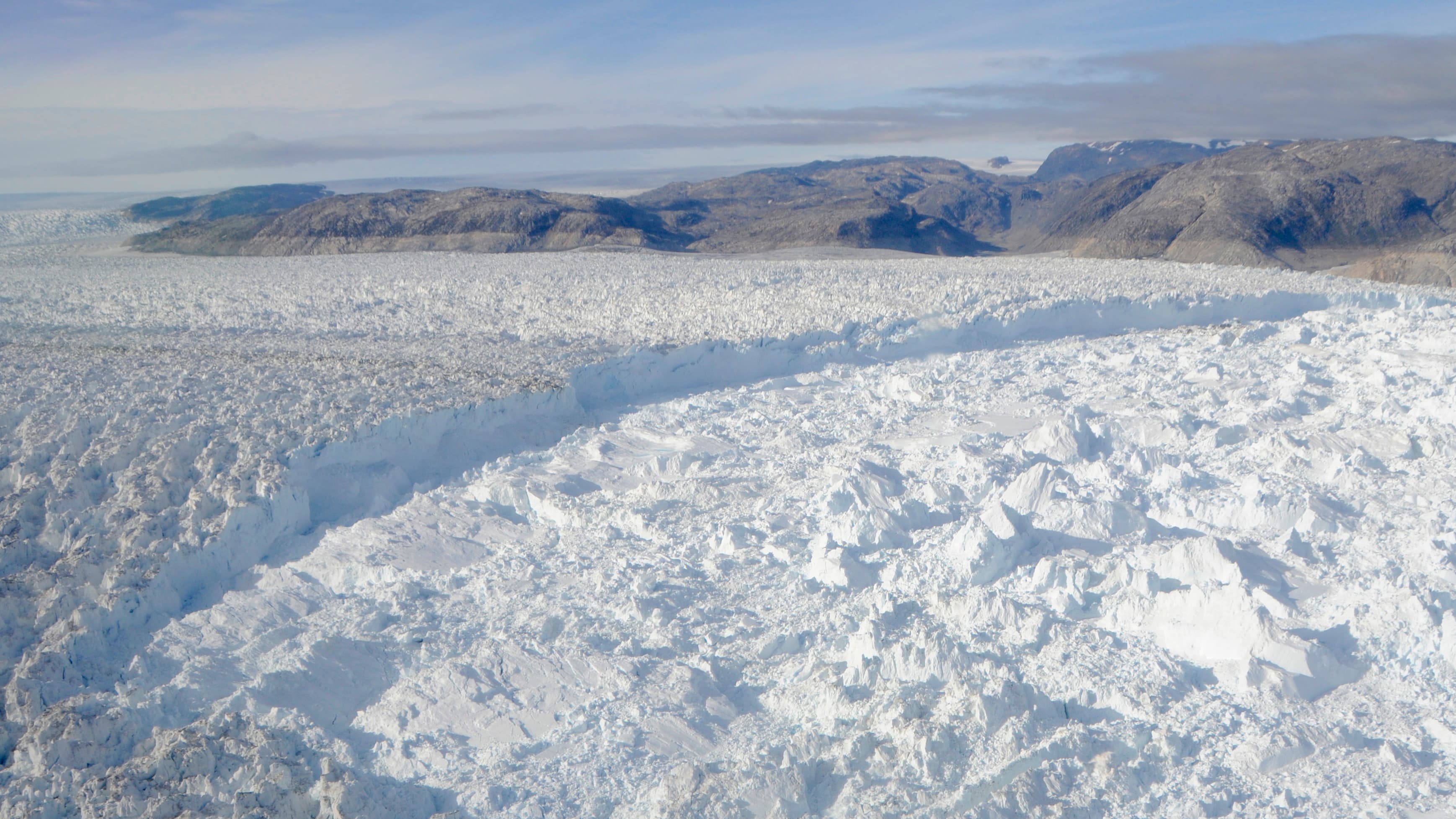 Dark rock above the Helheim glacier in southeastern Greenland marks its former level, before a sudden and dramatic retreat of hit many Greenland glaciers a decade ago. Scientists working on the Helheim and the fjord it drains into are looking for clues to