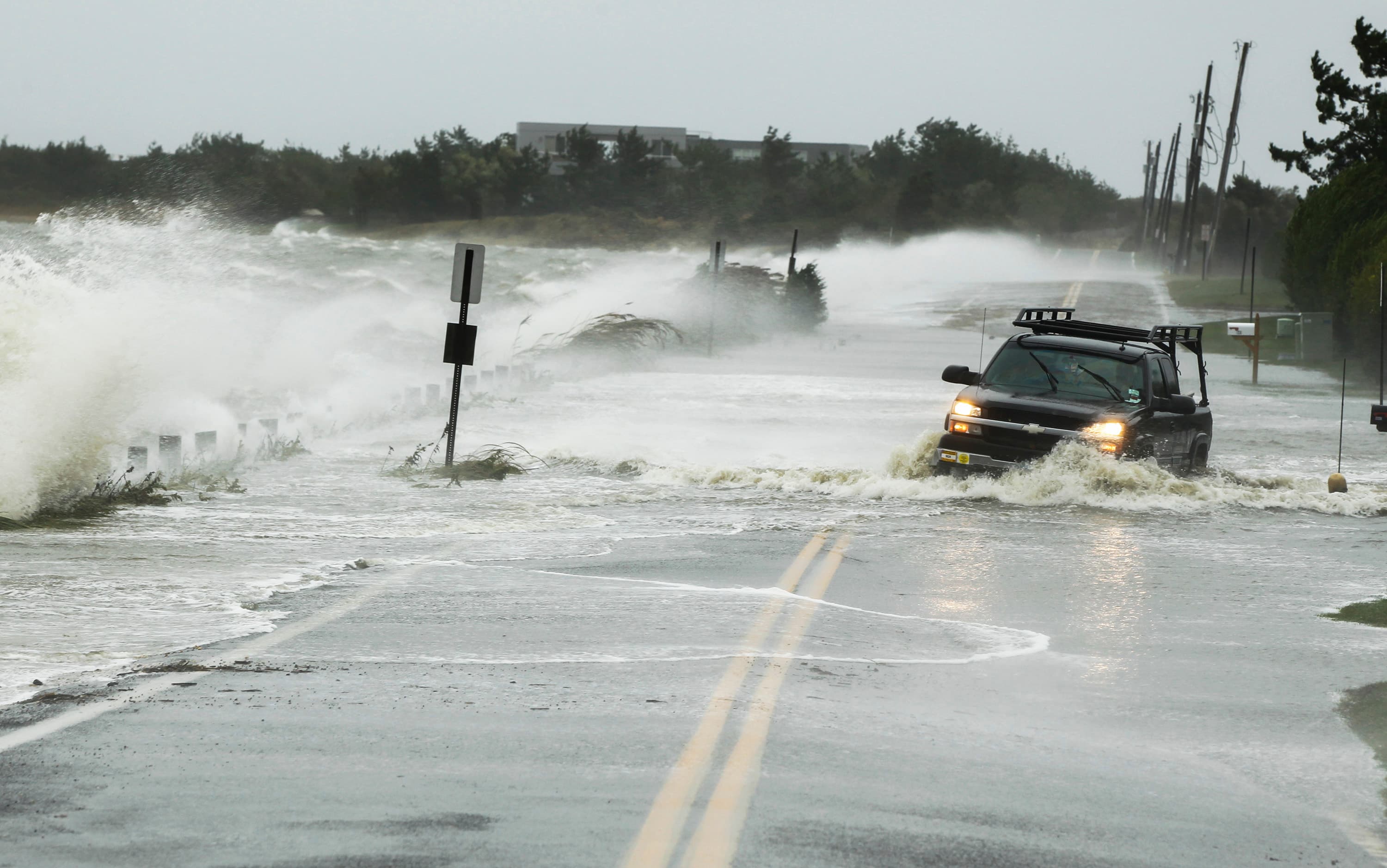 A truck drives through water pushed over a road by Hurricane Sandy in Southampton, New York, October 29, 2012.
