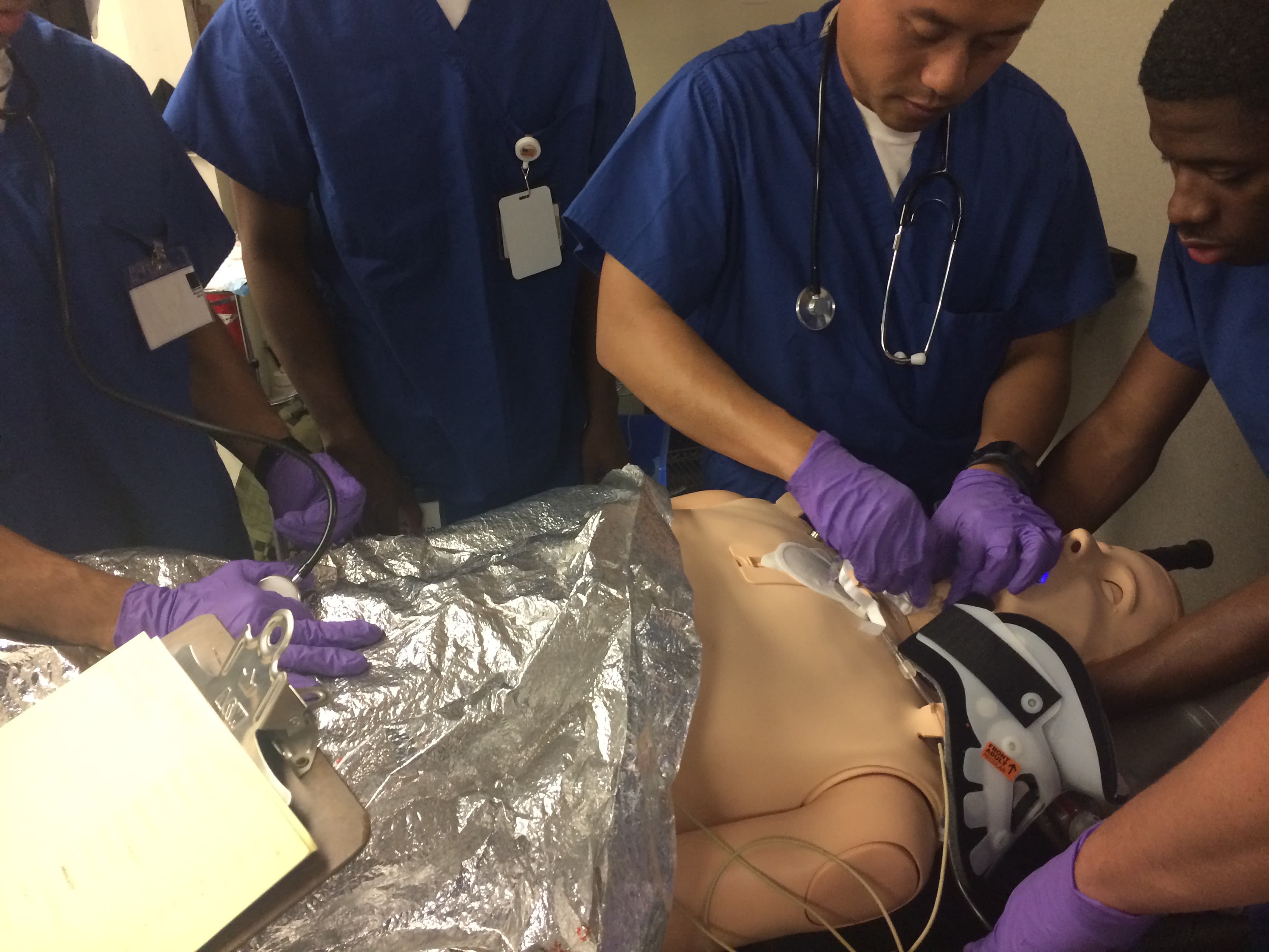 Trainees work on a dummy body.