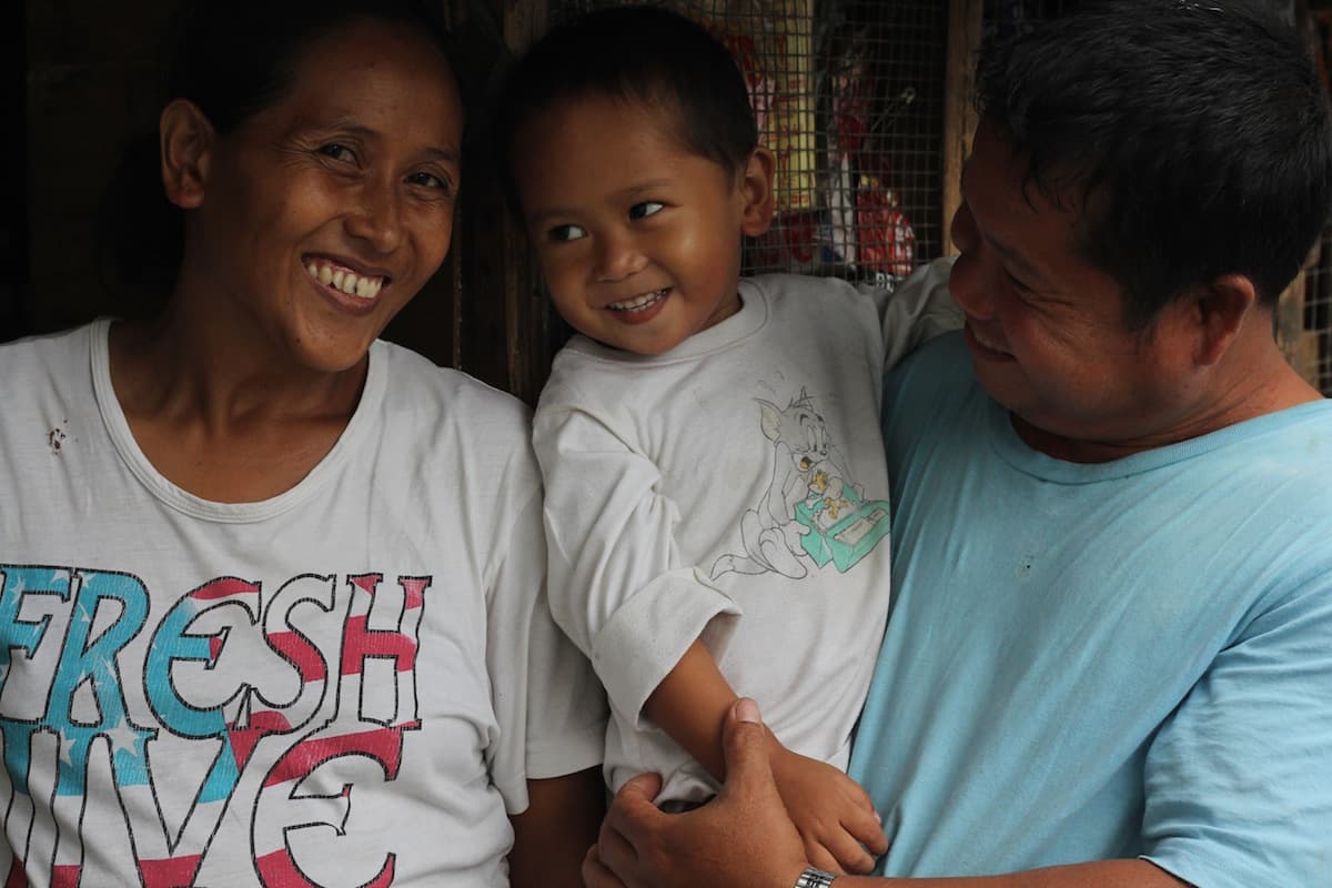 Jing Geronimo, inmate Roberto Maanyo, and their son Robert James outside the small shack the family shares on the grounds of the Leyte Provincial Prison on the outskirts of Tacloban.