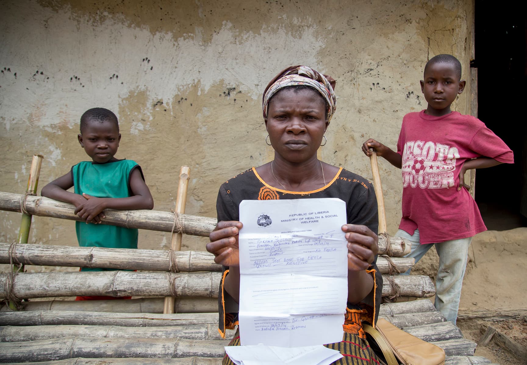 Ebola Survivor Gorma Dolo, holds an ebola free health certificate at her house in Freeman Reserve, Liberia.