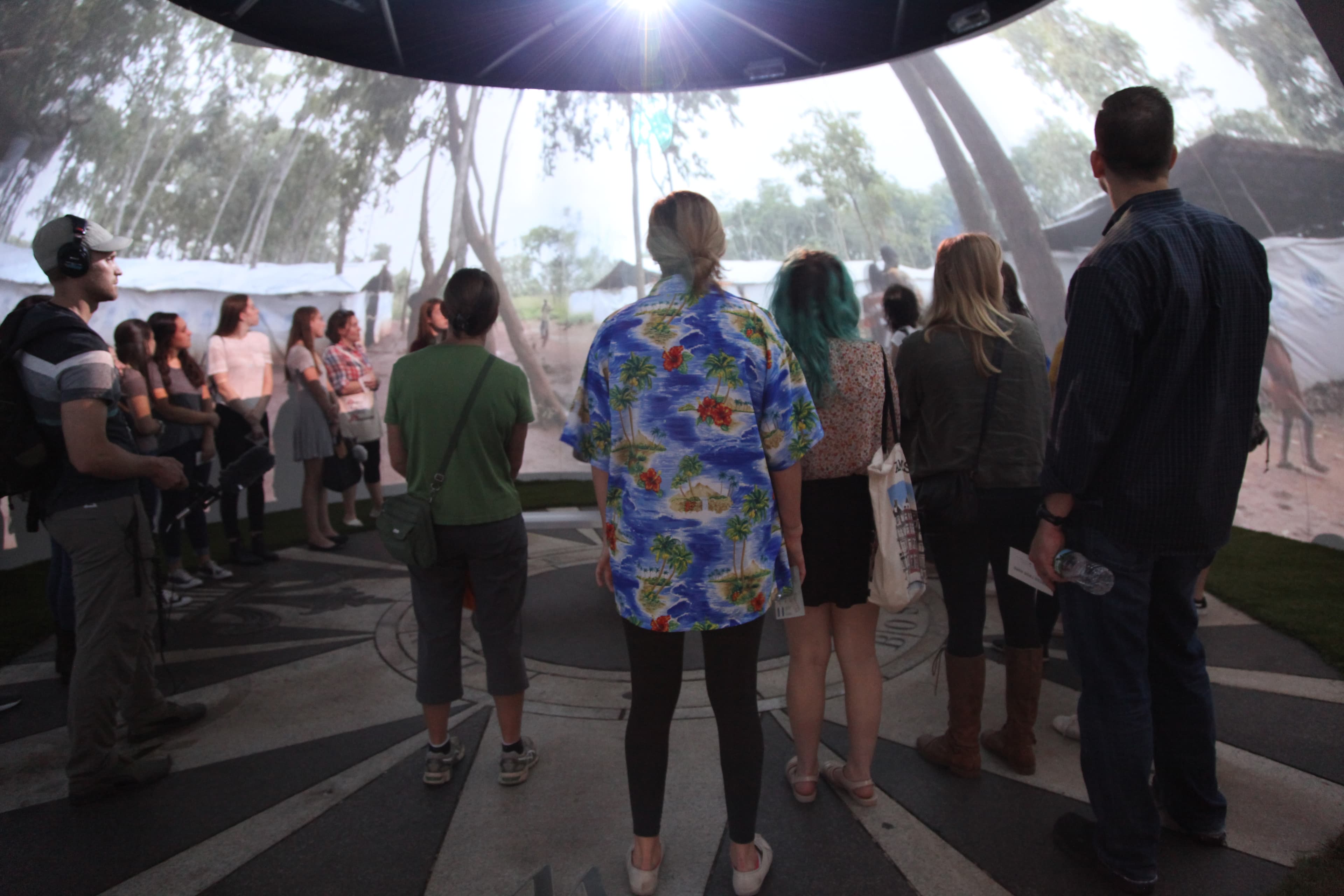 Students watch an immersive video at the 'Forced From Home' exhibit run by the international medical group Doctors Without Borders