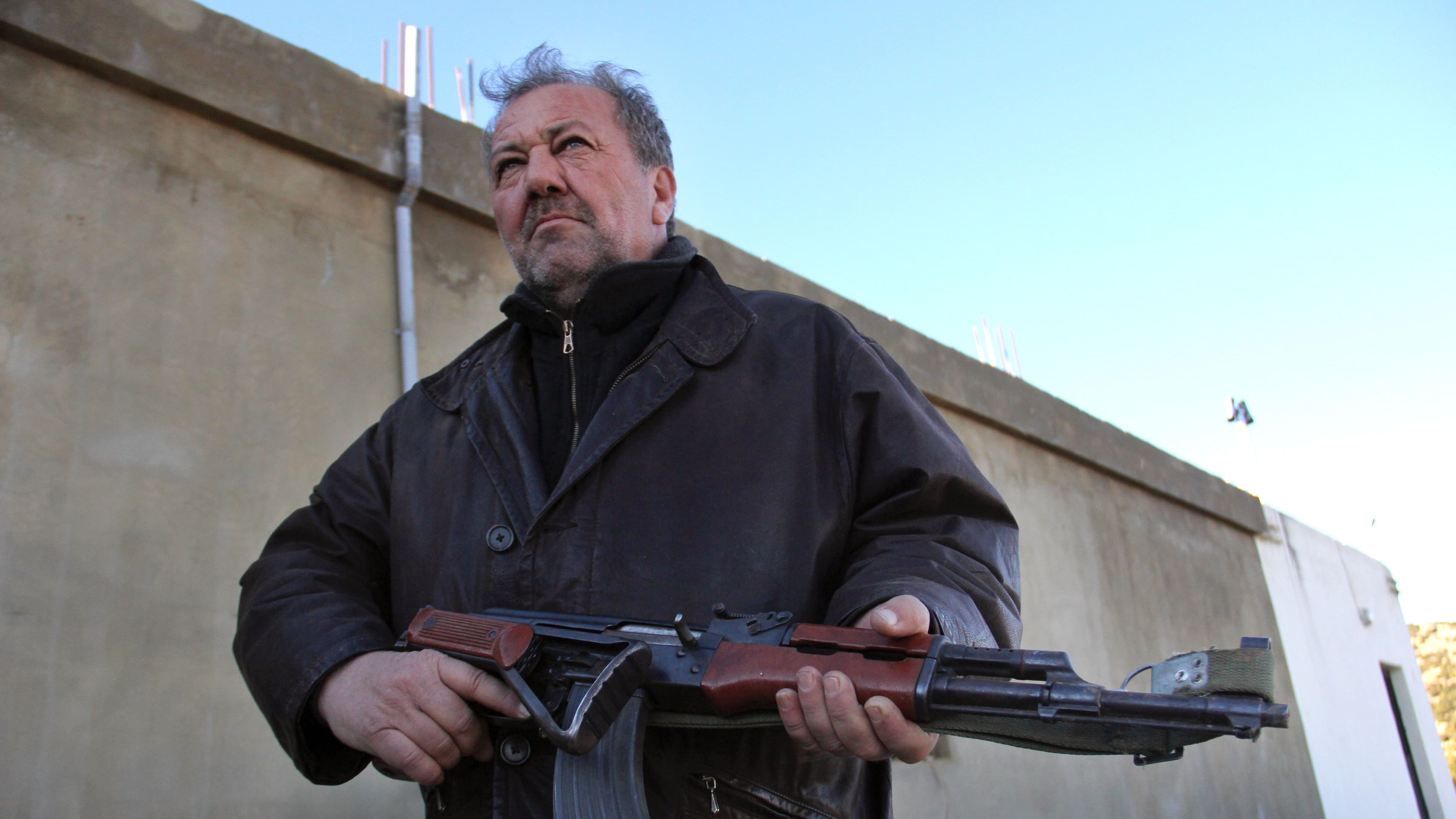 Ali Nasri Shamas holds a Kalashnikov assault rifle outside his hashish factory in Lebanon's Bekaa Valley. Shamas says the region's hash growers are ready to turn their weapons against any Islamic militants crossing the border from Syria.