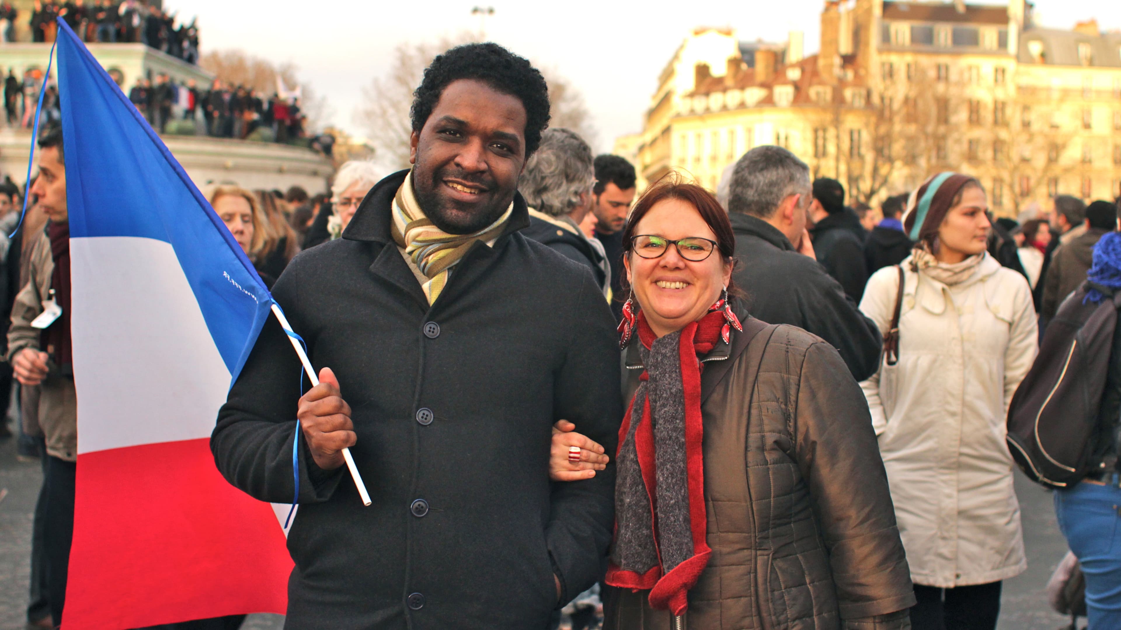 Paris couple Ahmed and Florence march hold the flag of France while participating in a march in support of freedom and people slain in the Charlie Hebdo terrorism attacks on January 12, 2015.