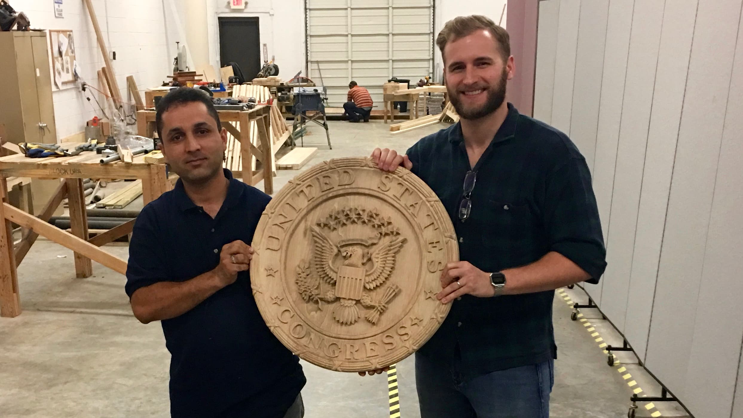 Najibullah Zahedi (left) is a refugee from Afghanistan who resettled in Georgia with his family. He's a student at the Lantern Project, run by Luke Keller, where he carved the US Congress seal.