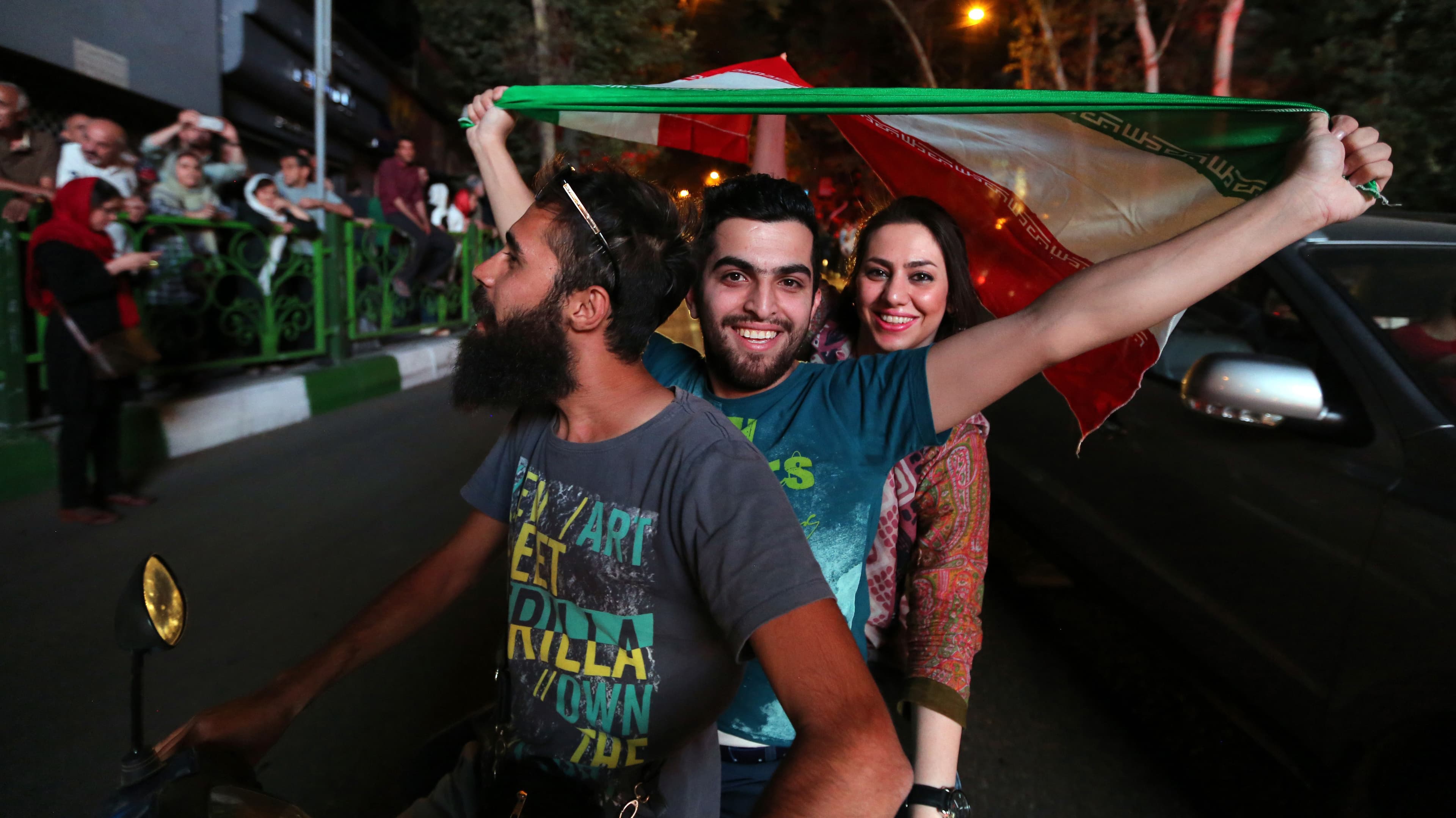 Iranians wave the national flag during celebrations in  Tehran on July 14, 2015, after Iran's nuclear negotiating team struck a deal with world powers in Vienna.