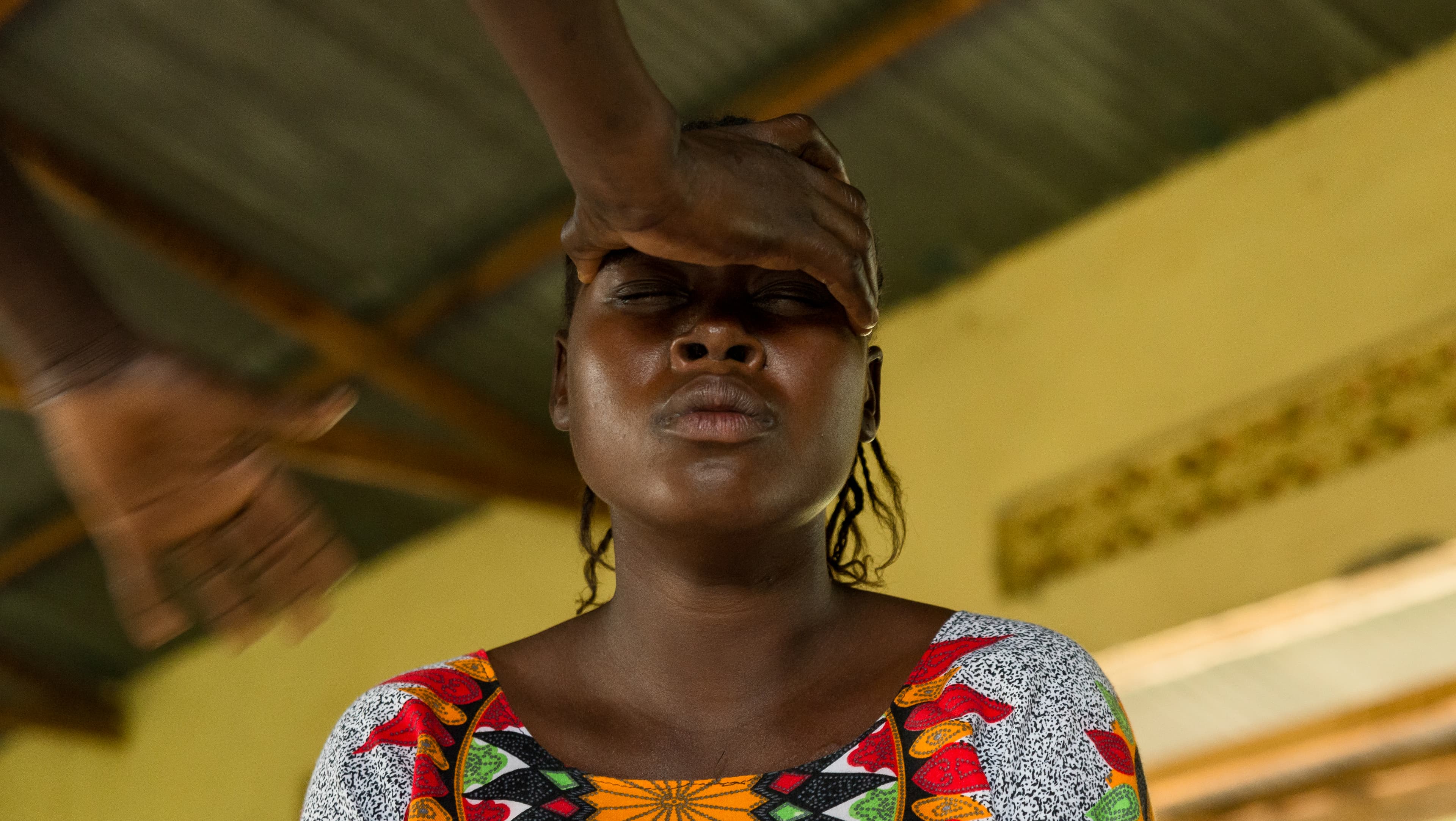 Jacqueline, 24, a South Sudanese refugee living in Uganda receives a blessing from her minister.