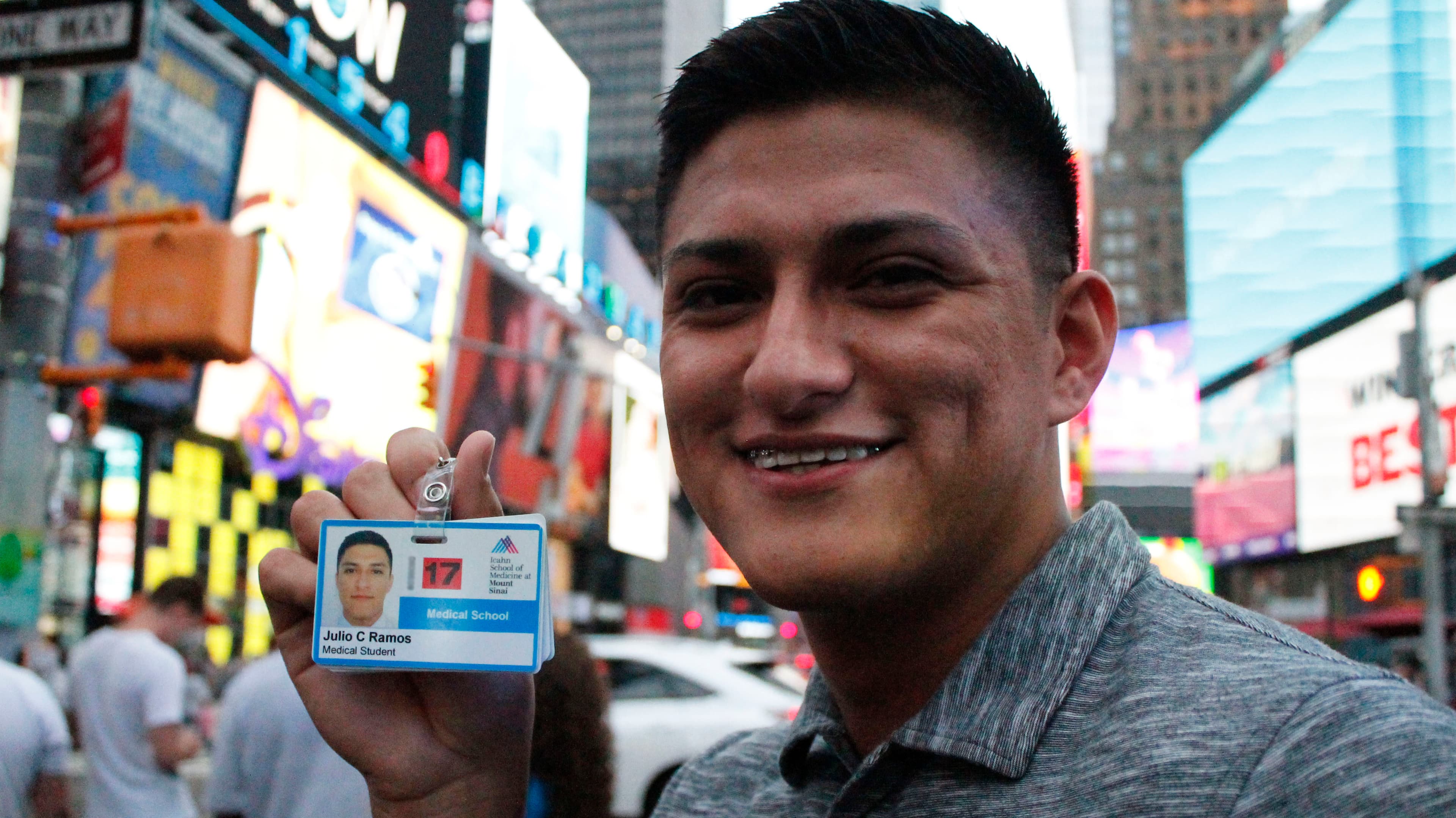 Man holding up ID card for medical school