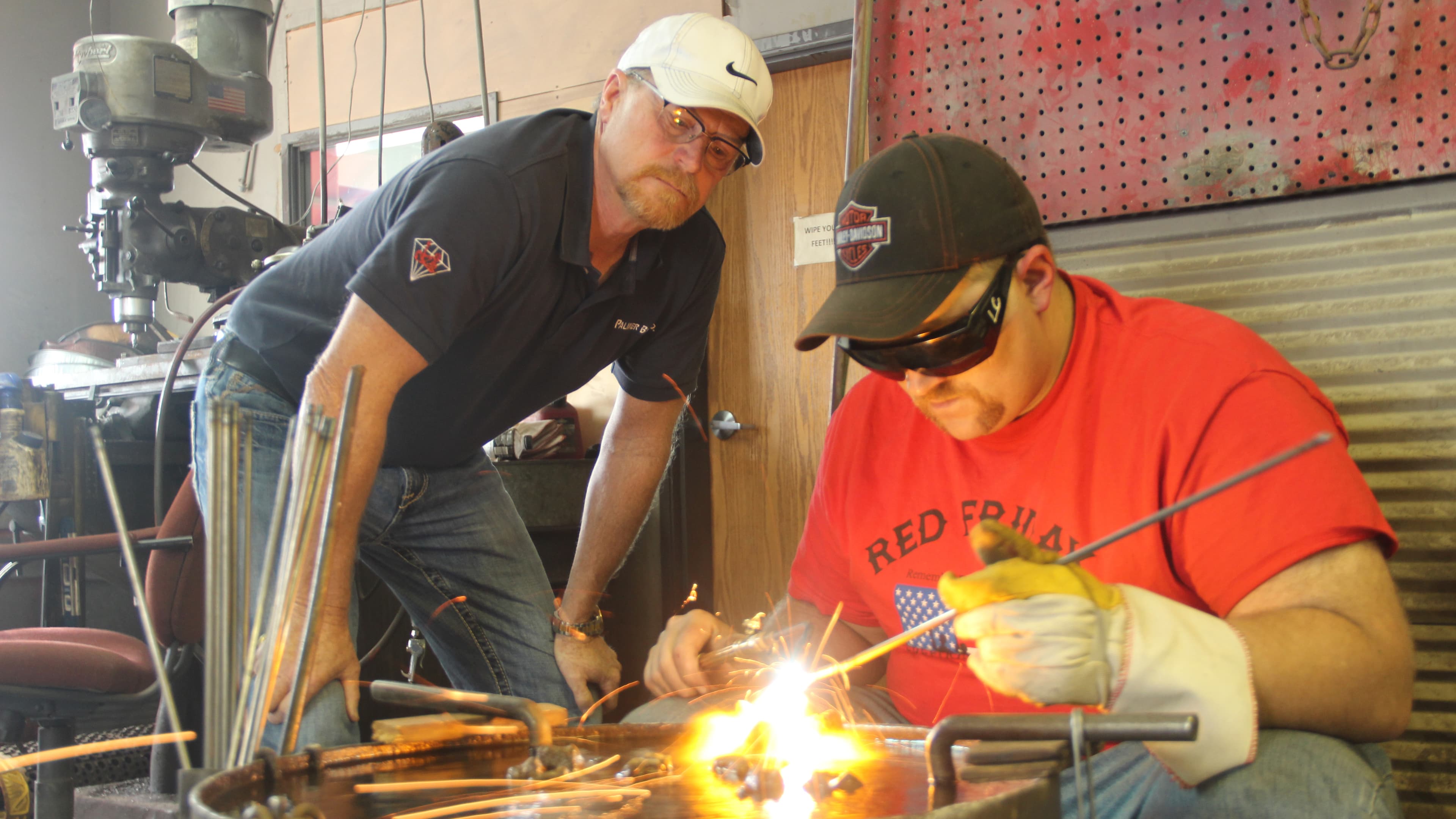 Kevin Christensen looks on as his son, Lane Christensen, sharpens an industrial drill bit. Christensen’s four-person company turned into an international exporter in a matter of months with help from the US Commercial Service.