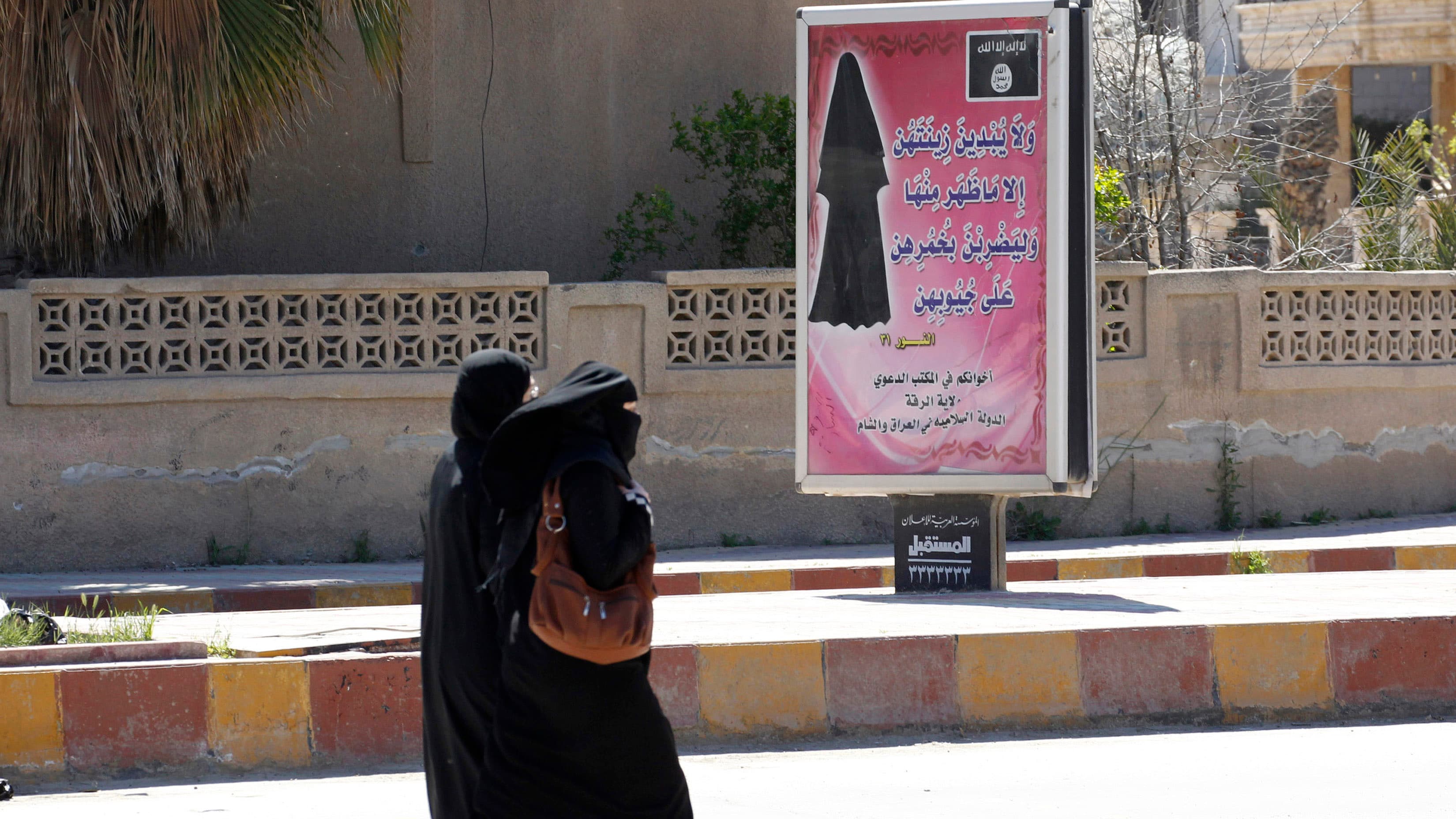 A billboard displays a verse from the Koran that urges women to wear a hijab in the northern province of Raqqa in March. ISIS has imposed sweeping restrictions like this in areas where it has gained control.
