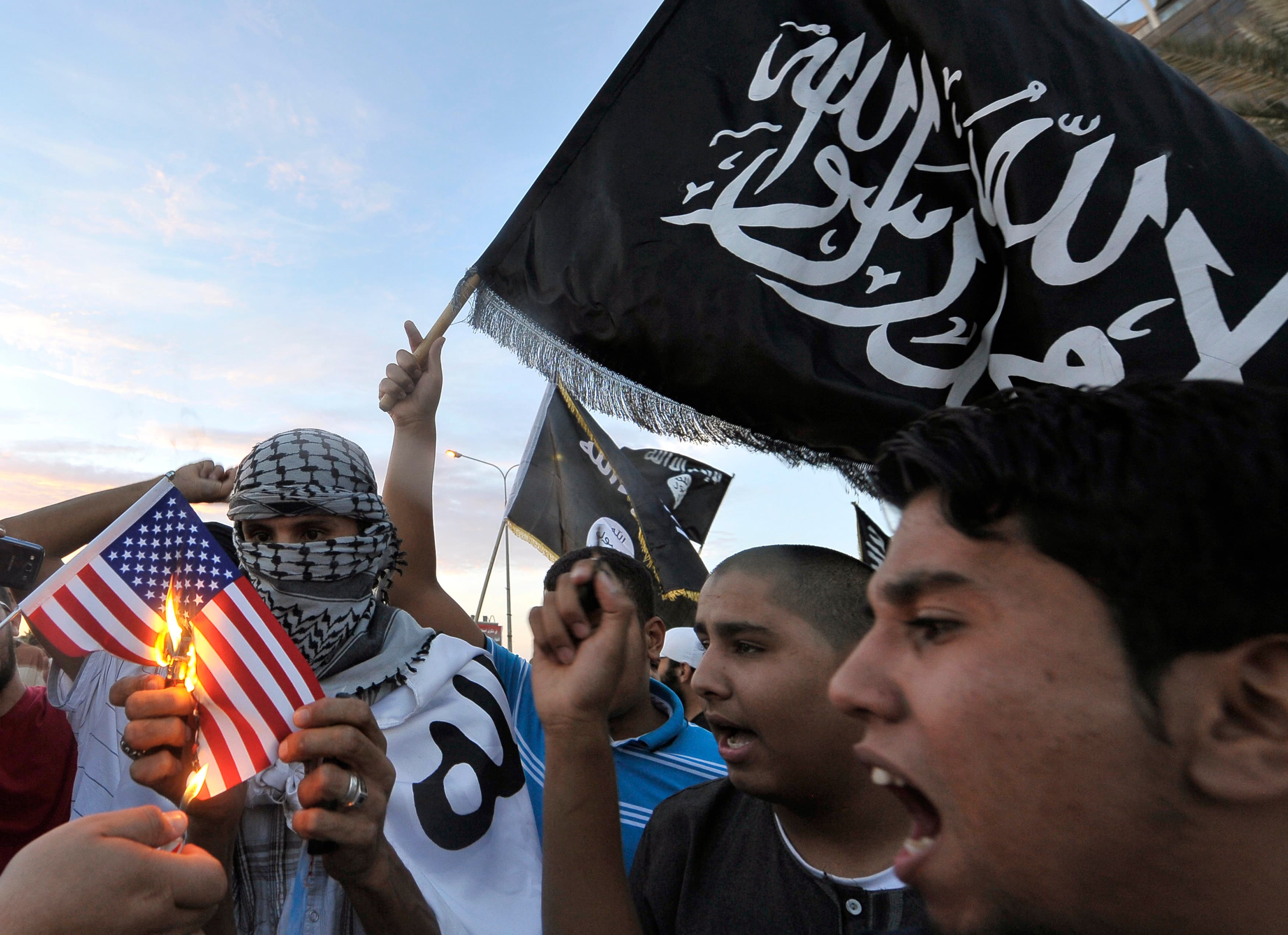 Protesters burn a replica of the US flag during a demonstration against the capture of Nazih al-Ragye, in Benghazi October 7, 2013.
