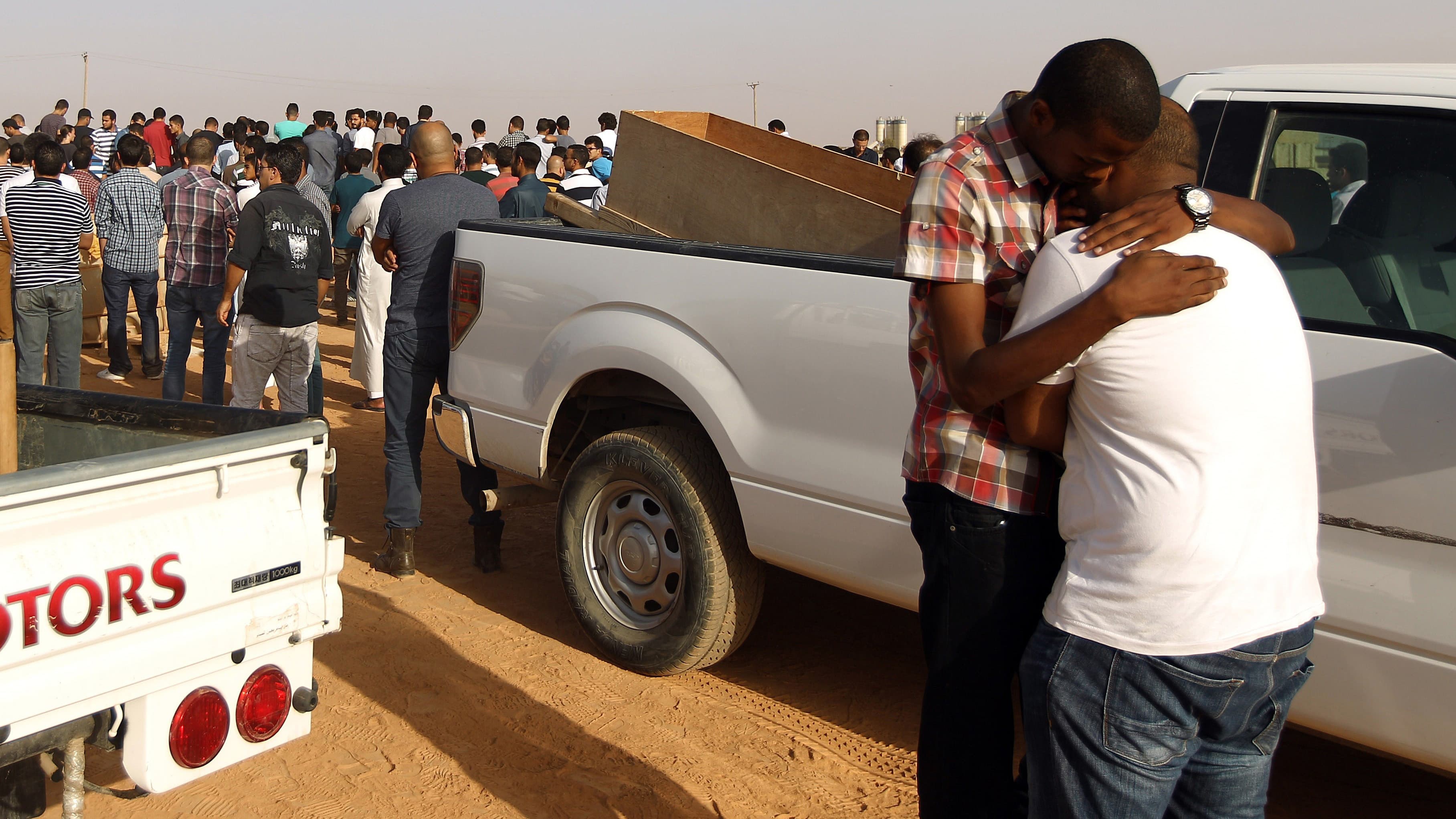 Two men hug during the funeral for Libyan activist Tawfik Bin Saud in Benghazi on September 20, 2014. Tawfik was killed, along with a friend, late on September 19, by unknown gunmen as they were driving home in Libya's eastern coastal city of Benghazi.