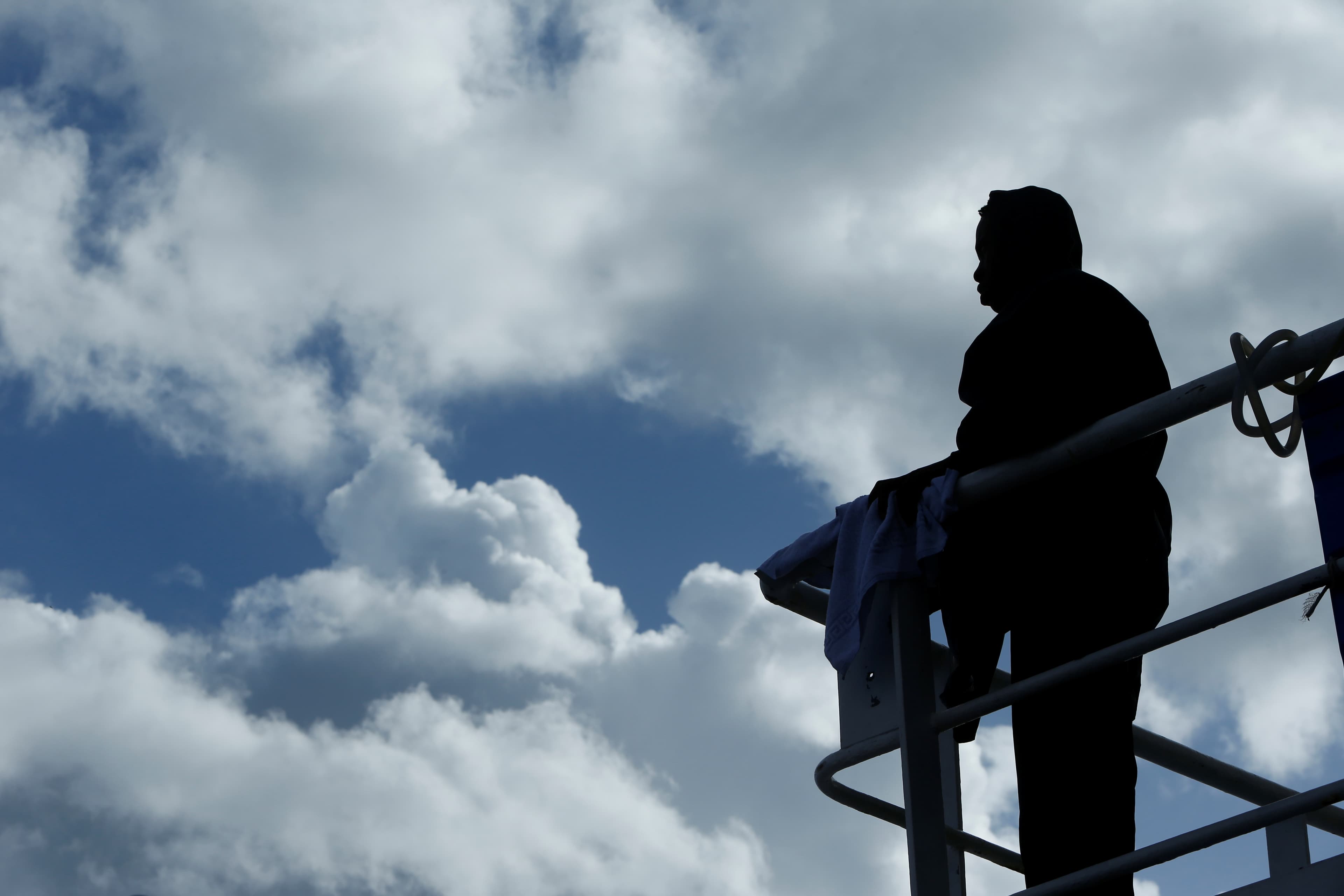 A migrant looks out to sea off the coast of Libya.