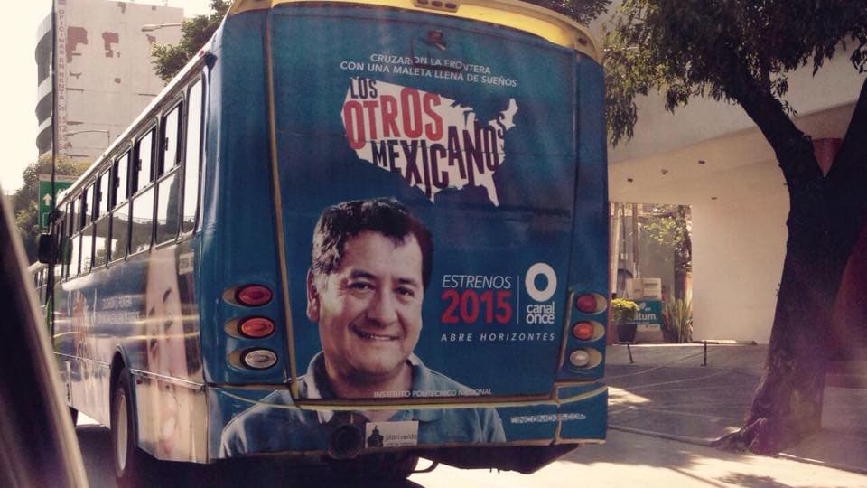 An advertisement for "Los Otros Mexicanos" featuring Betto Arcos is plastered on a bus.