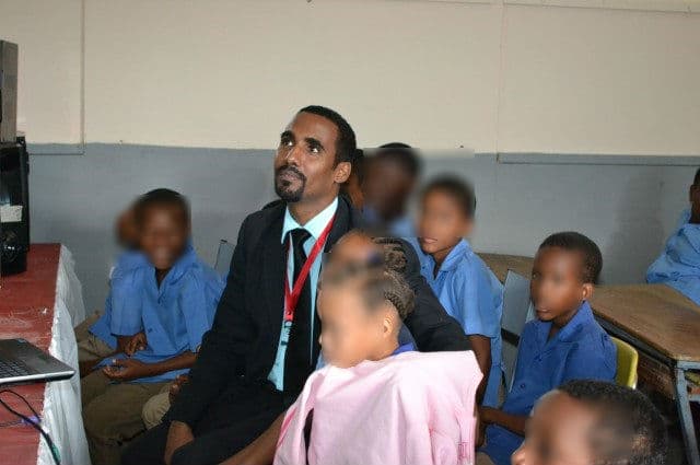 Corporal Kevin Watson of Jamaica's Major Organized Crime and Anti-Corruption Agency talks with students during a lottery scamming prevention campaign in Jamaican schools.