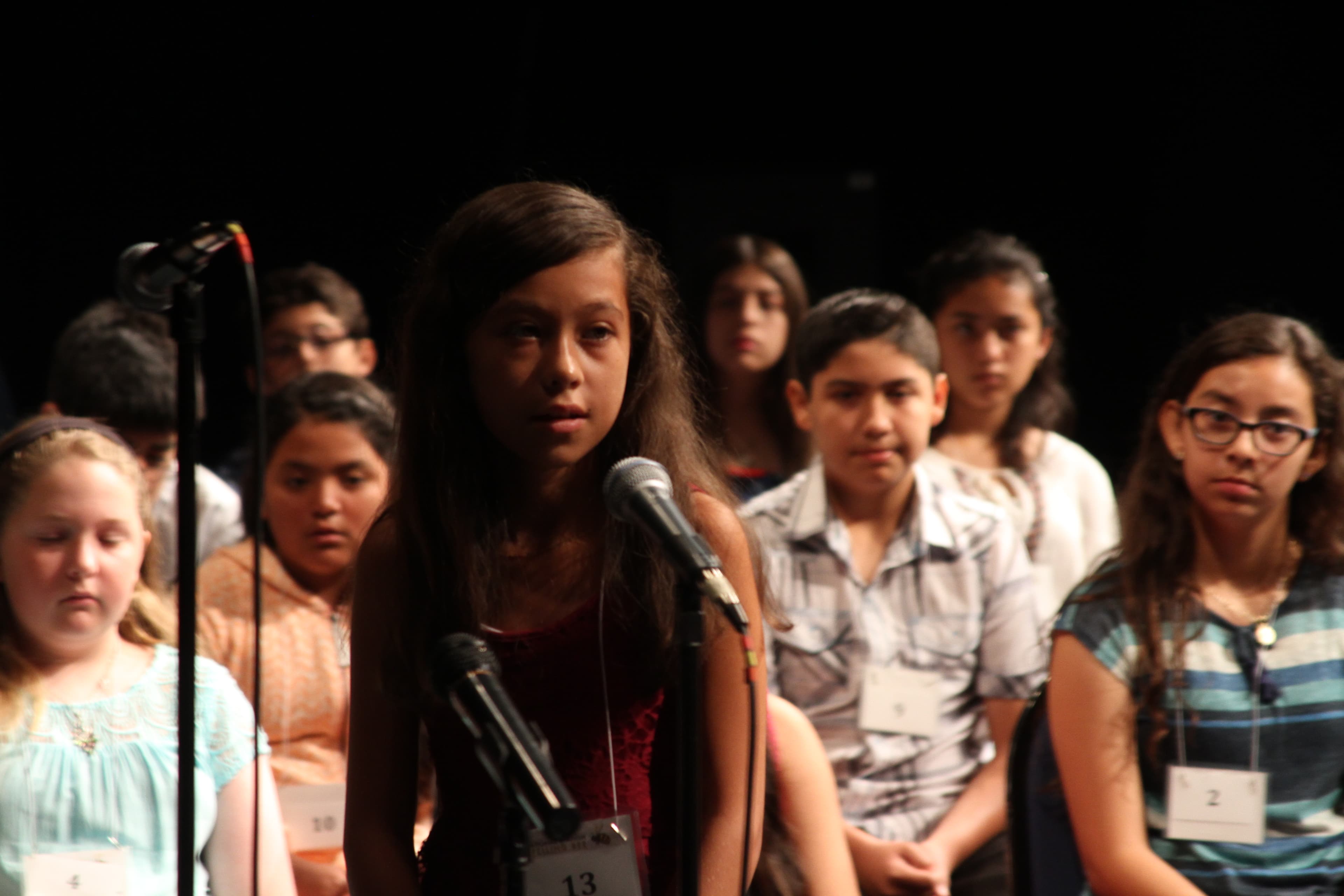 Students on stage participating in spelling bee