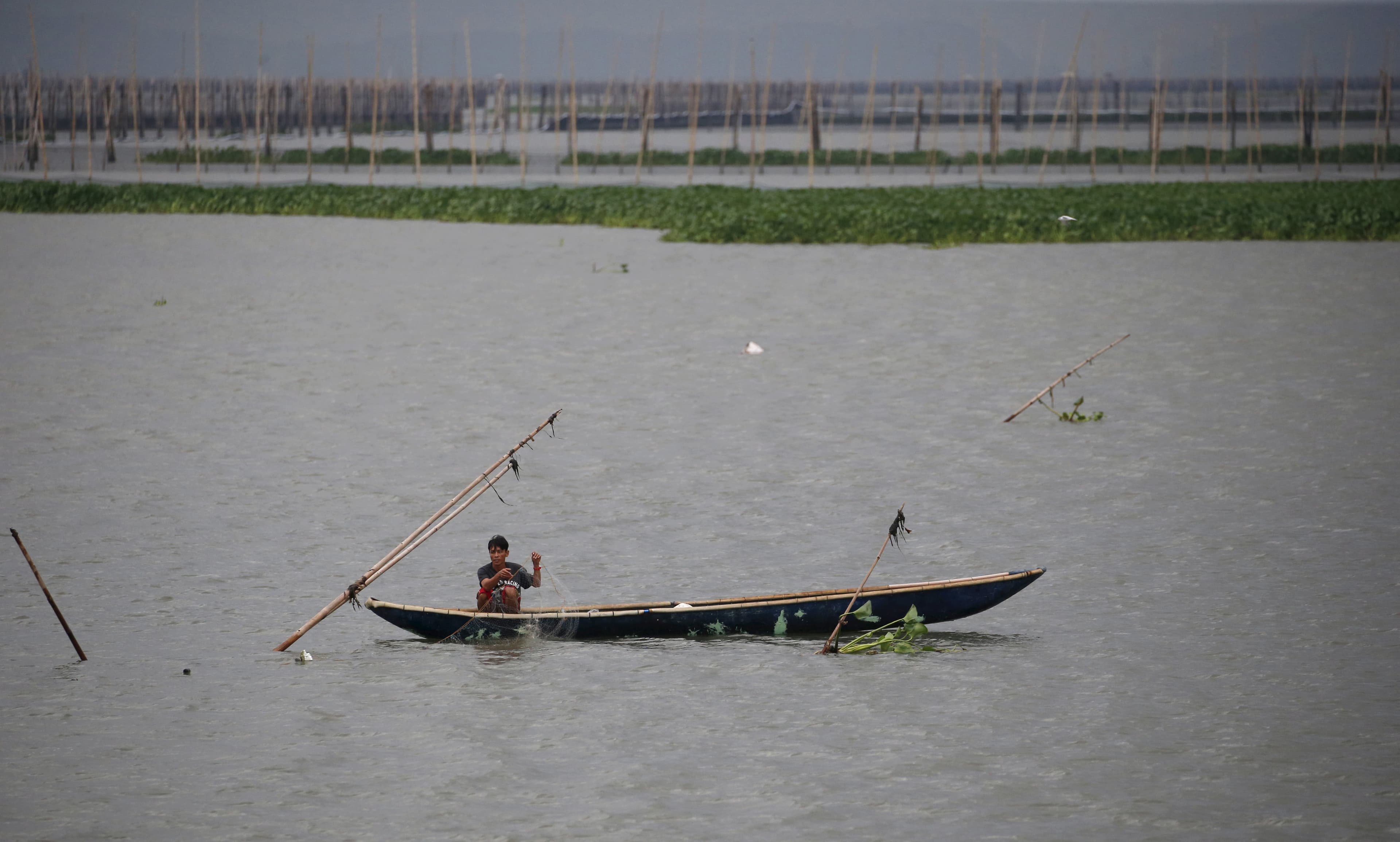 A resident fishes in the waters near Manila, Philippines, amid heavy current and winds brought by Typhoon Melor in some parts of the country. Wide areas of the central Philippines were plunged into darkness on Tuesday as Melor barreled into the coconut-gr