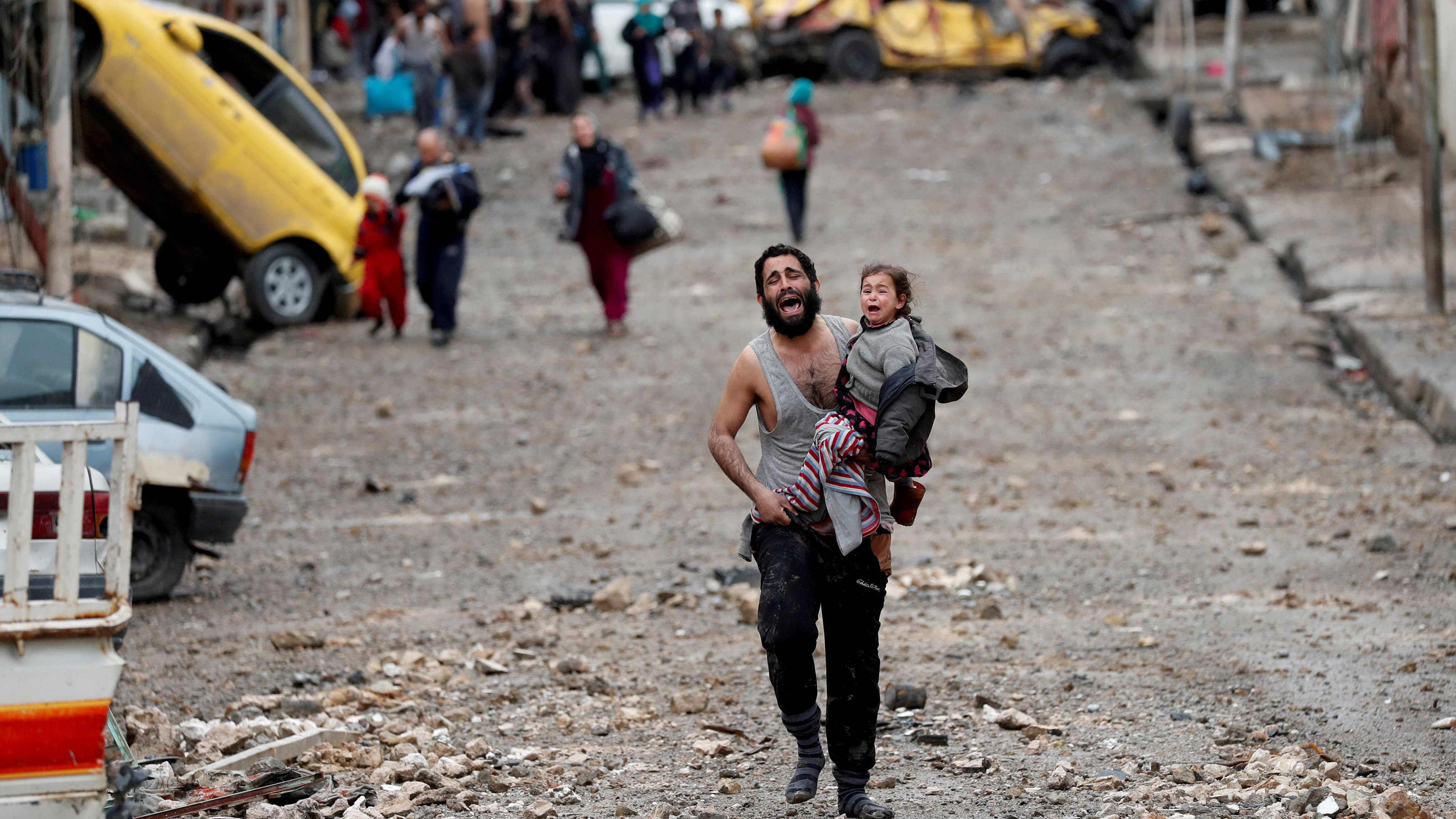 A man cries as he carries his daughter from an ISIS-held part of Mosul toward Iraqi special forces soldiers during a battle for the Iraqi city, on March 4.