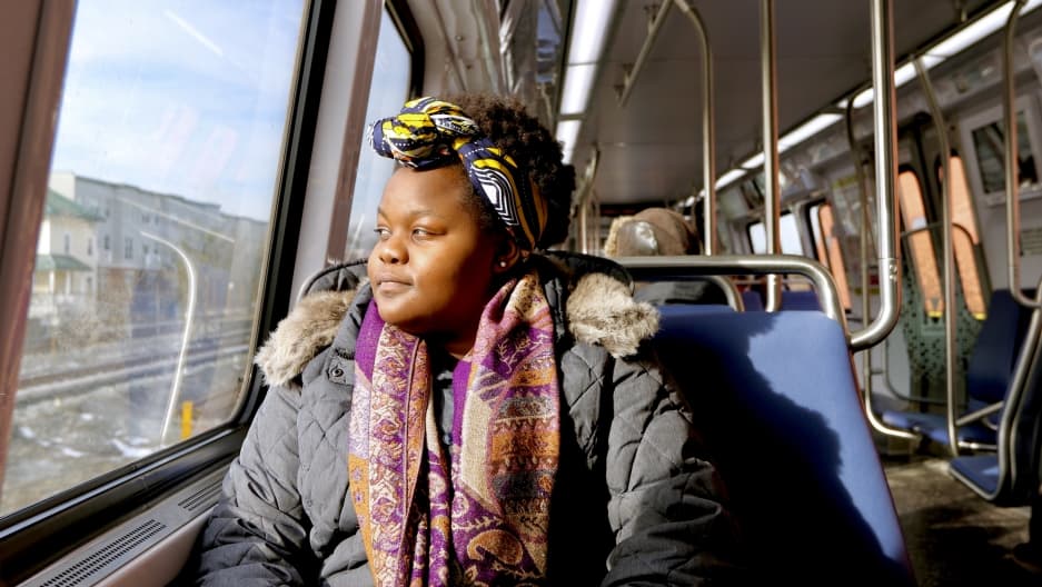 A woman riding the train looks out of the window.