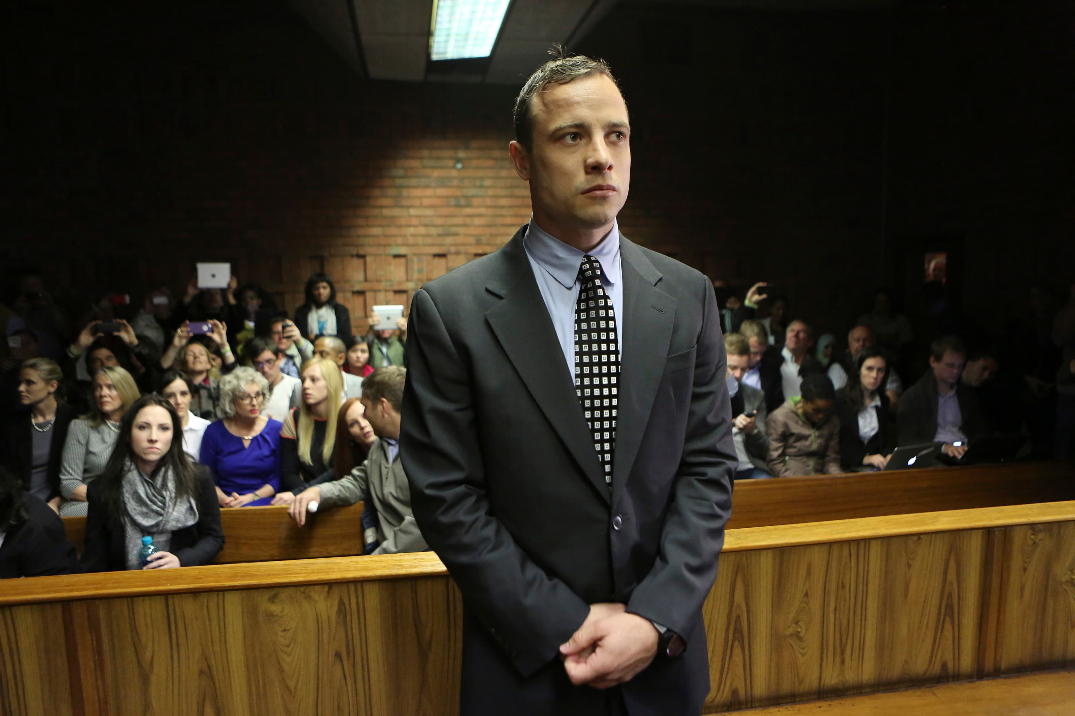 Oscar Pistorius enters the dock before court proceedings at the Pretoria Magistrates court in 2013.