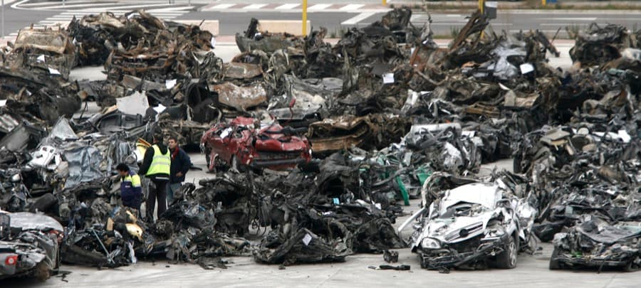 Security workers stand amid the wreckage of cars removed from the remains of a parking garage that was the scene of a car bomb at Madrid's Barajas Airport.