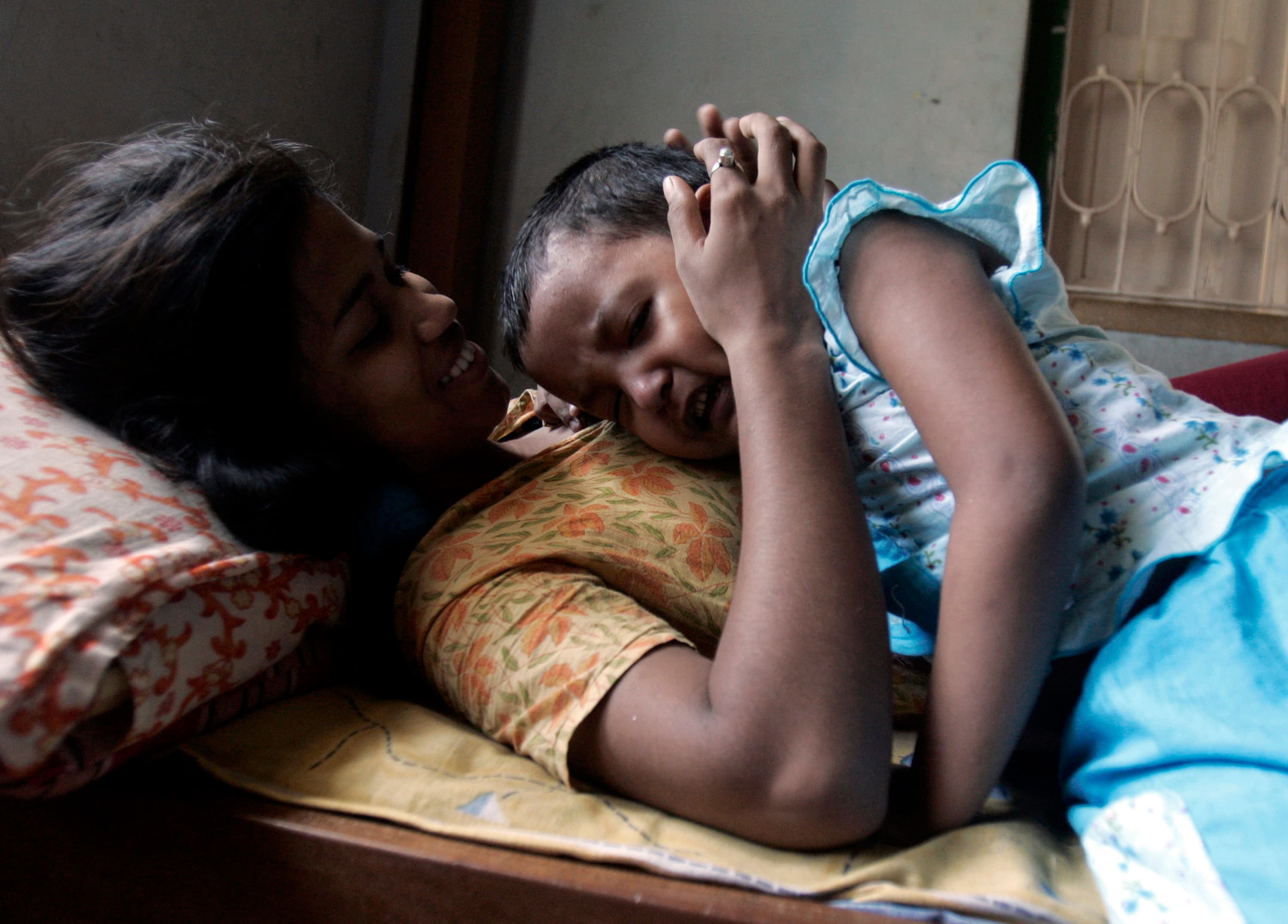 Child of a sex worker comforts another child of another sex worker.