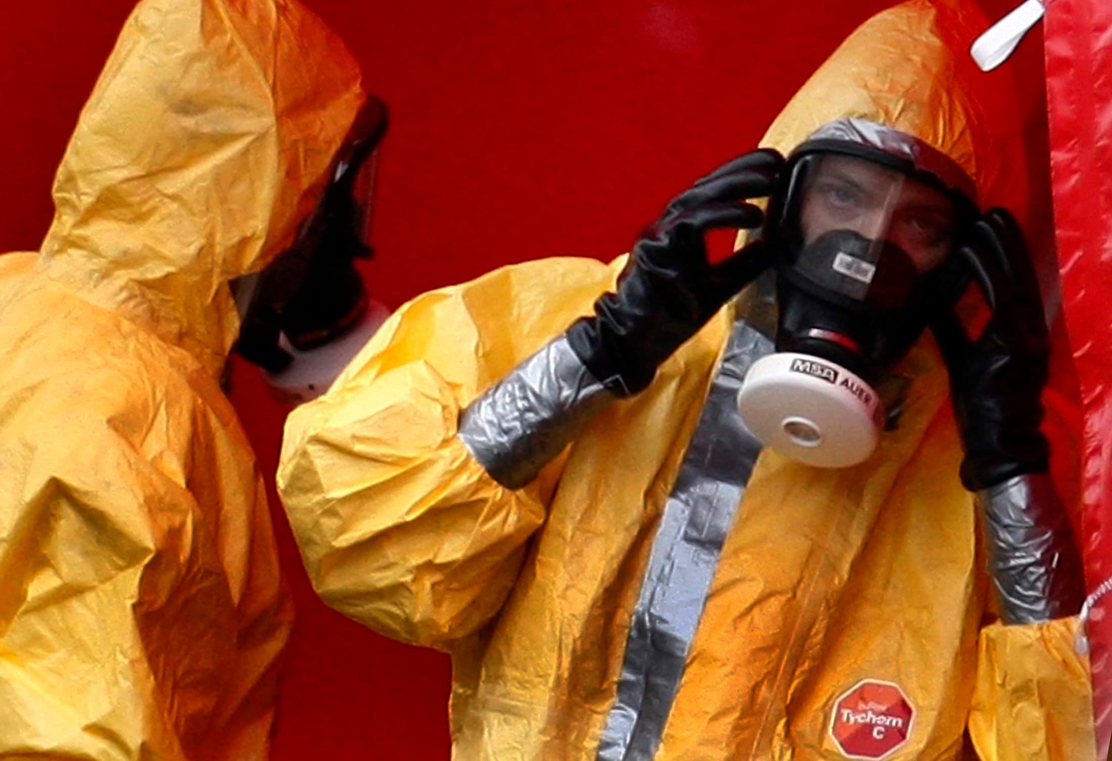 Workers in biohazard suits stand at the entry of a sealed-off poultry farm in Trumling, southern Germany, on Sep. 8, 2007. The H5N1 bird flu virus had been found in several ducks at a nearby poultry farm.