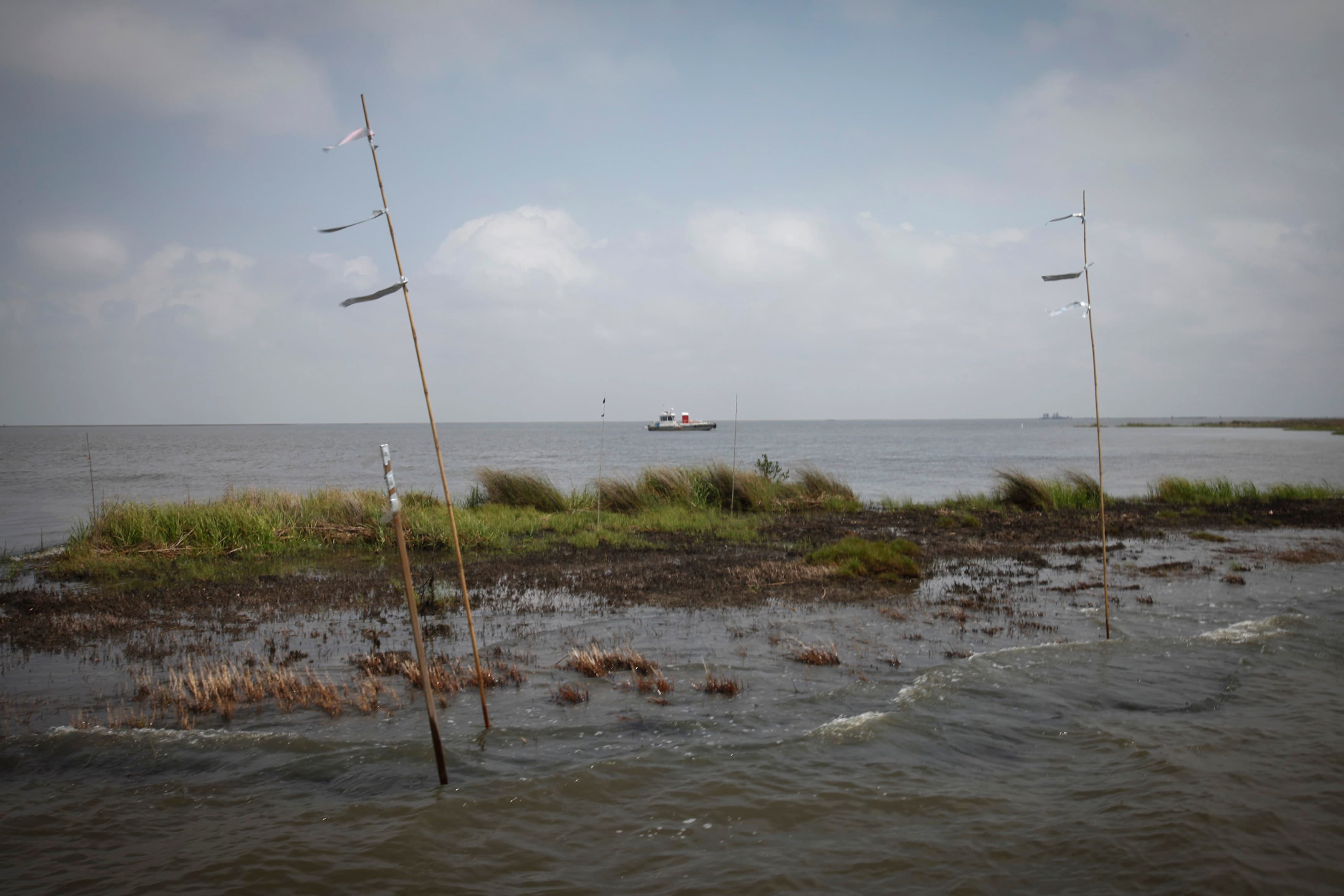 A work boat passes an oiled marshland one year after the Deepwater Horizon oil spill in Bay Jimmy near Myrtle Grove, Louisiana.
