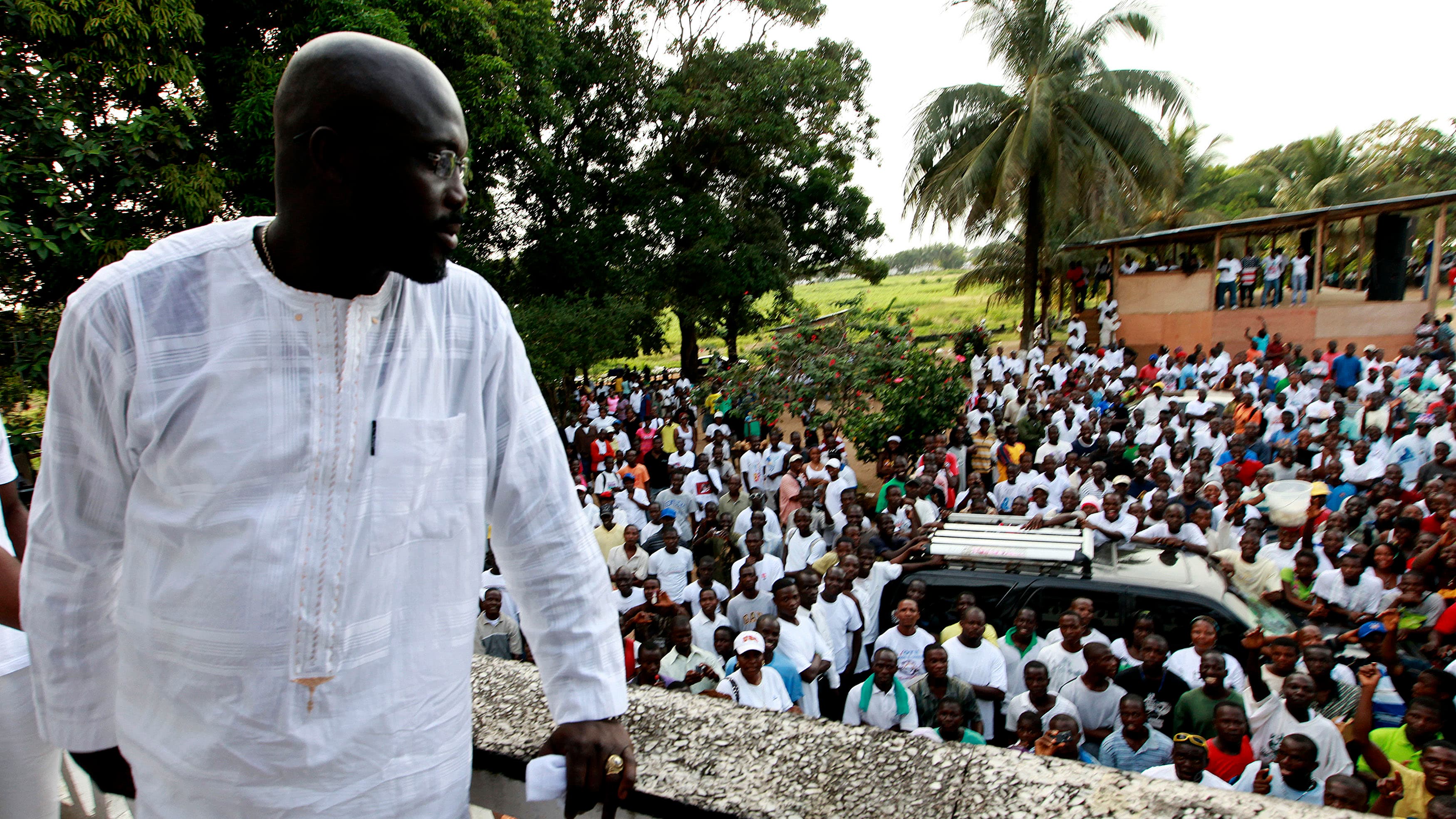 George Weah, a former soccer star, warlord and model looks on as he stands at the balcony after a news conference at his headquarters in Monrovia November 5, 2011.
