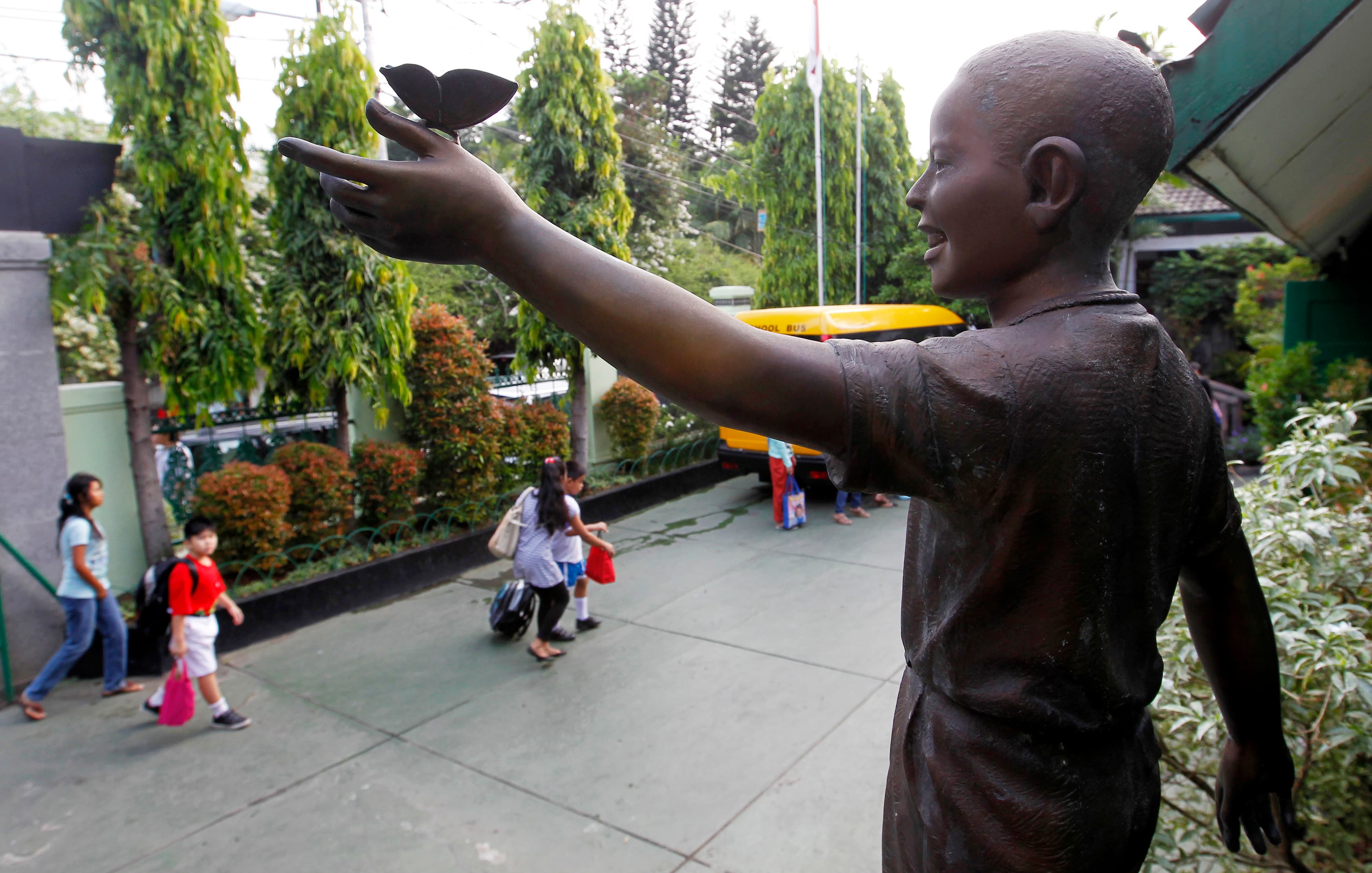 Statue of a young boy looking out over school yard