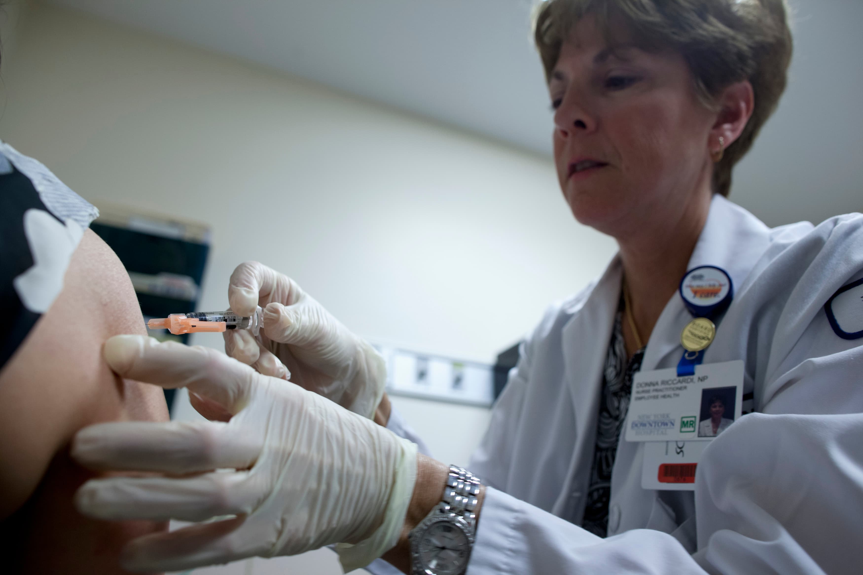 Nurse Donna Riccardi administers a shot of Influenze virus vaccine to patient Deanna Joa at the New York Downtown Hospital in New York on January 10, 2013.