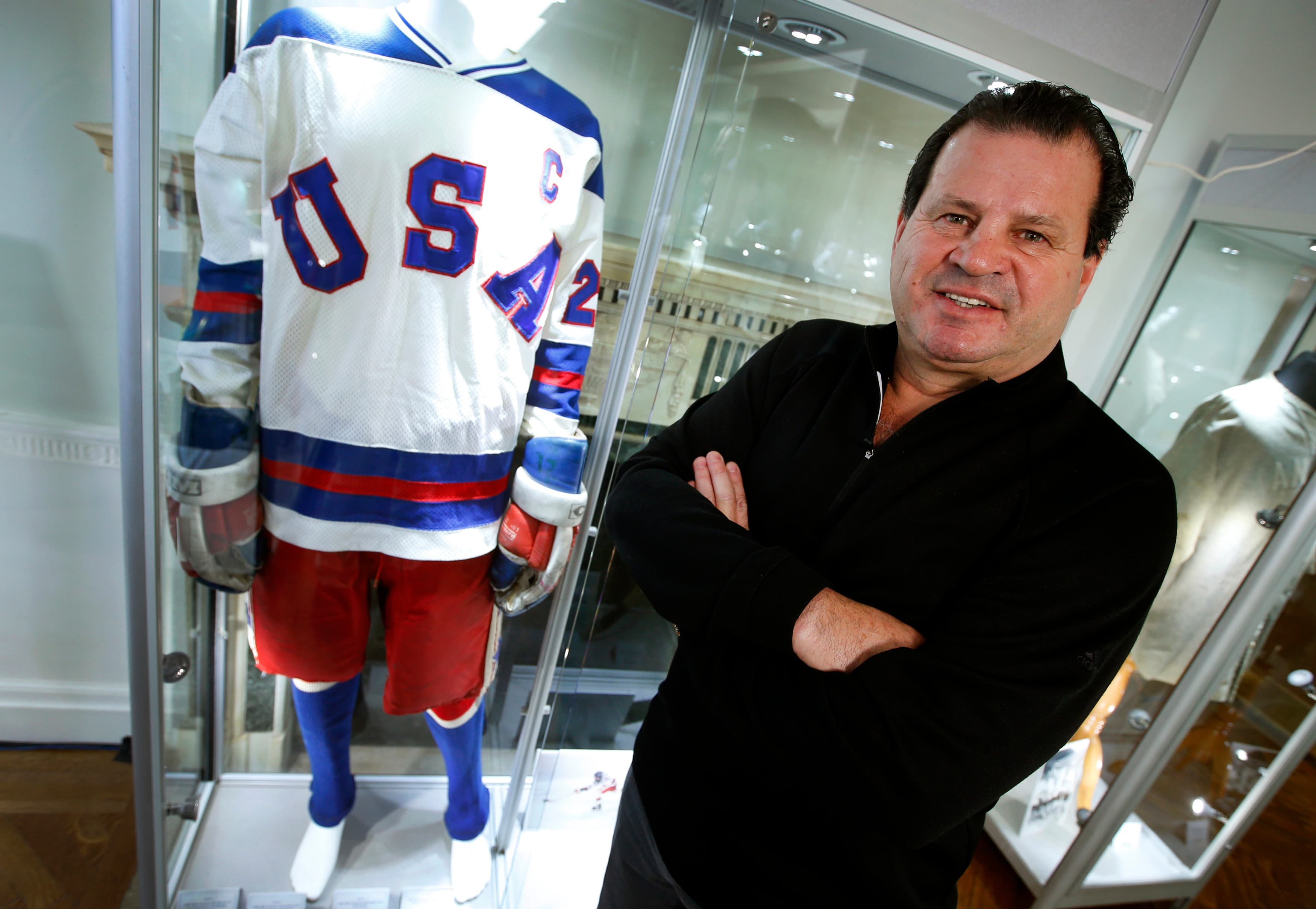 Mike Eruzione, captain of the 1980 gold medal winning U.S. Olympic ice hockey team poses next to the jersey and uniform he wore when the U.S. defeated the Soviet Union in what is known as the "Miracle on Ice" at Heritage Auctions in New York City