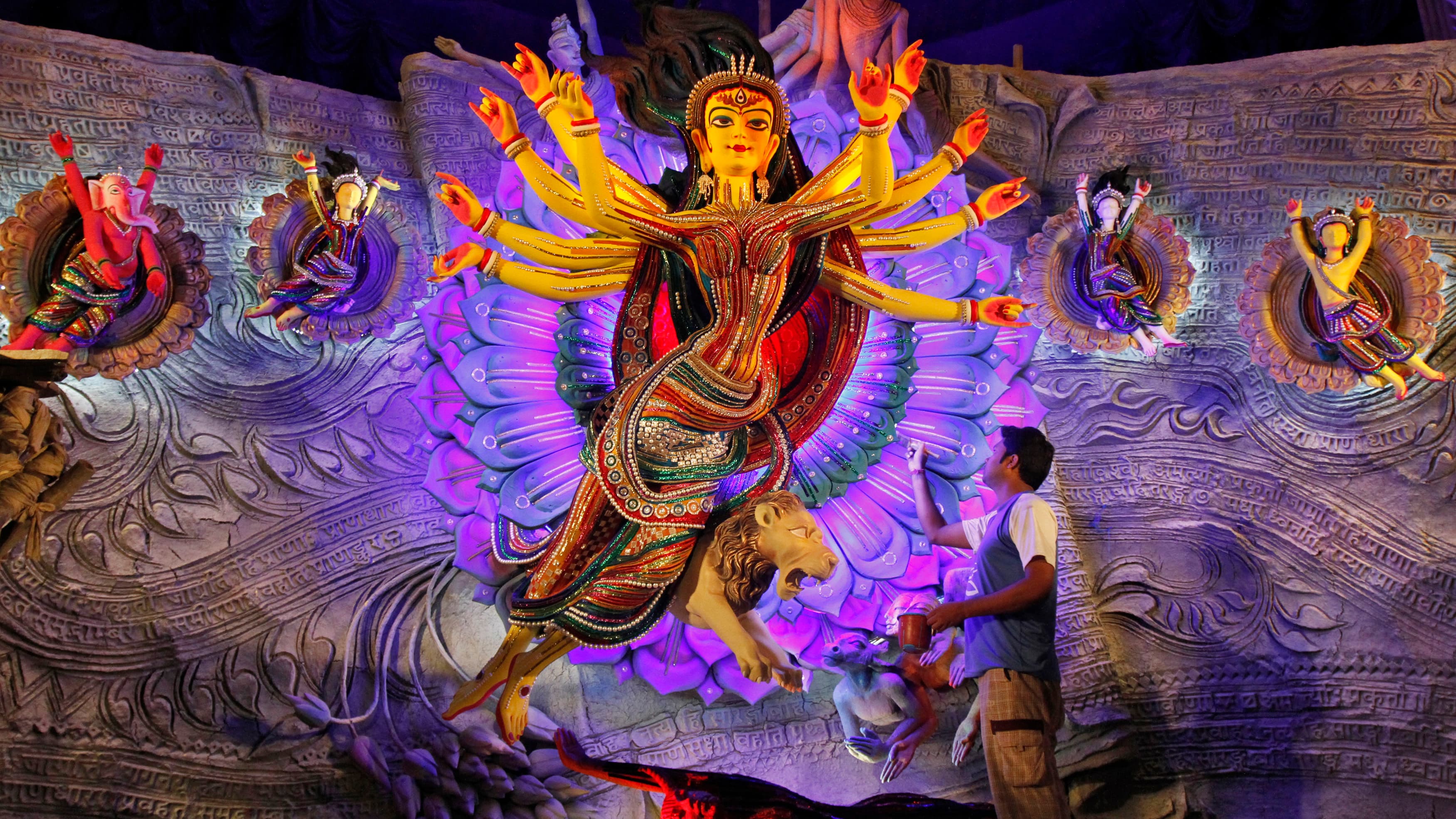 An artist applies the finishing touches on an idol of the Hindu goddess Durga in preparation for a yearly festival for Bengali Hindus.