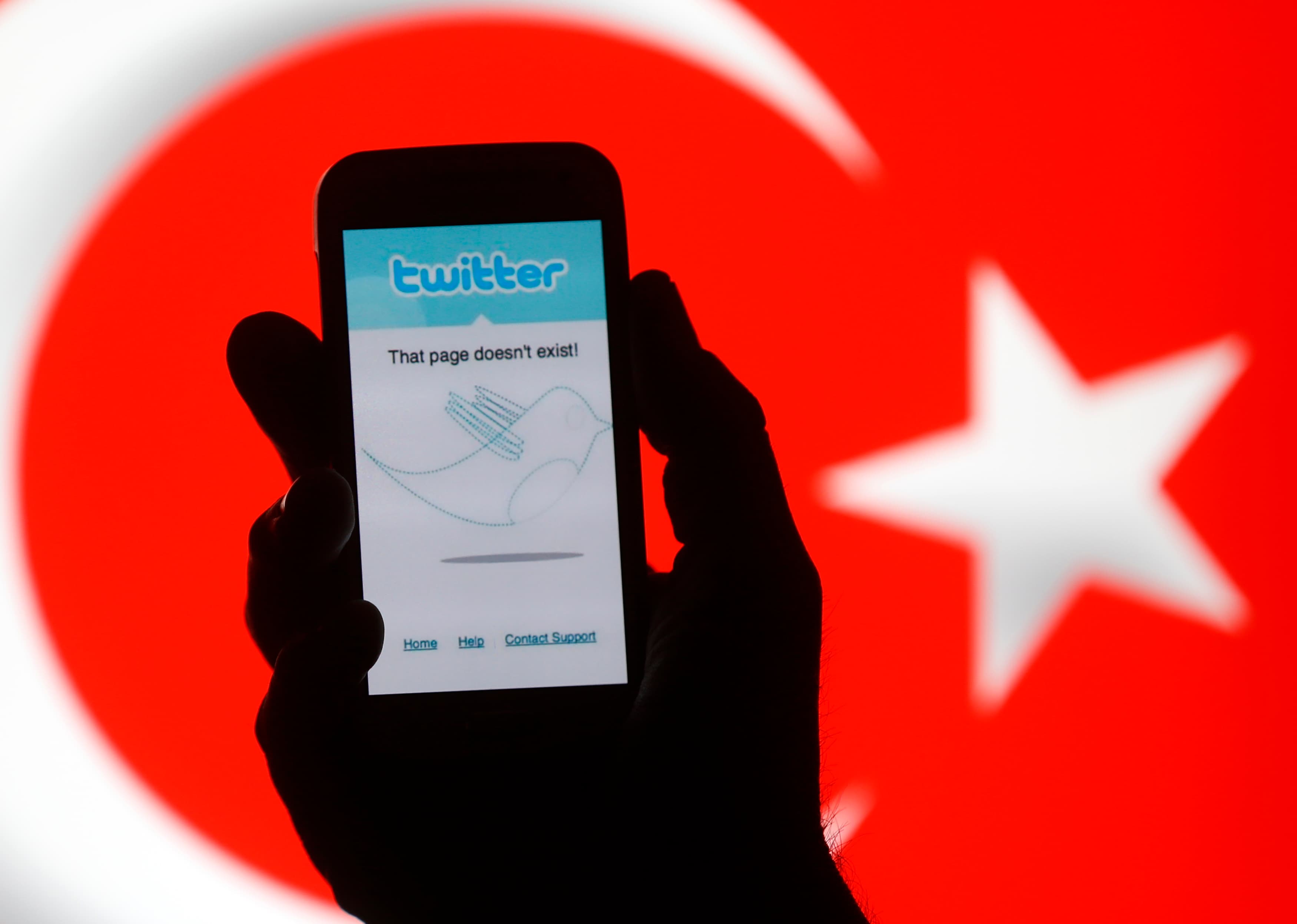 A phone displaying a Twitter error message is show in front of the Turkish national flag.