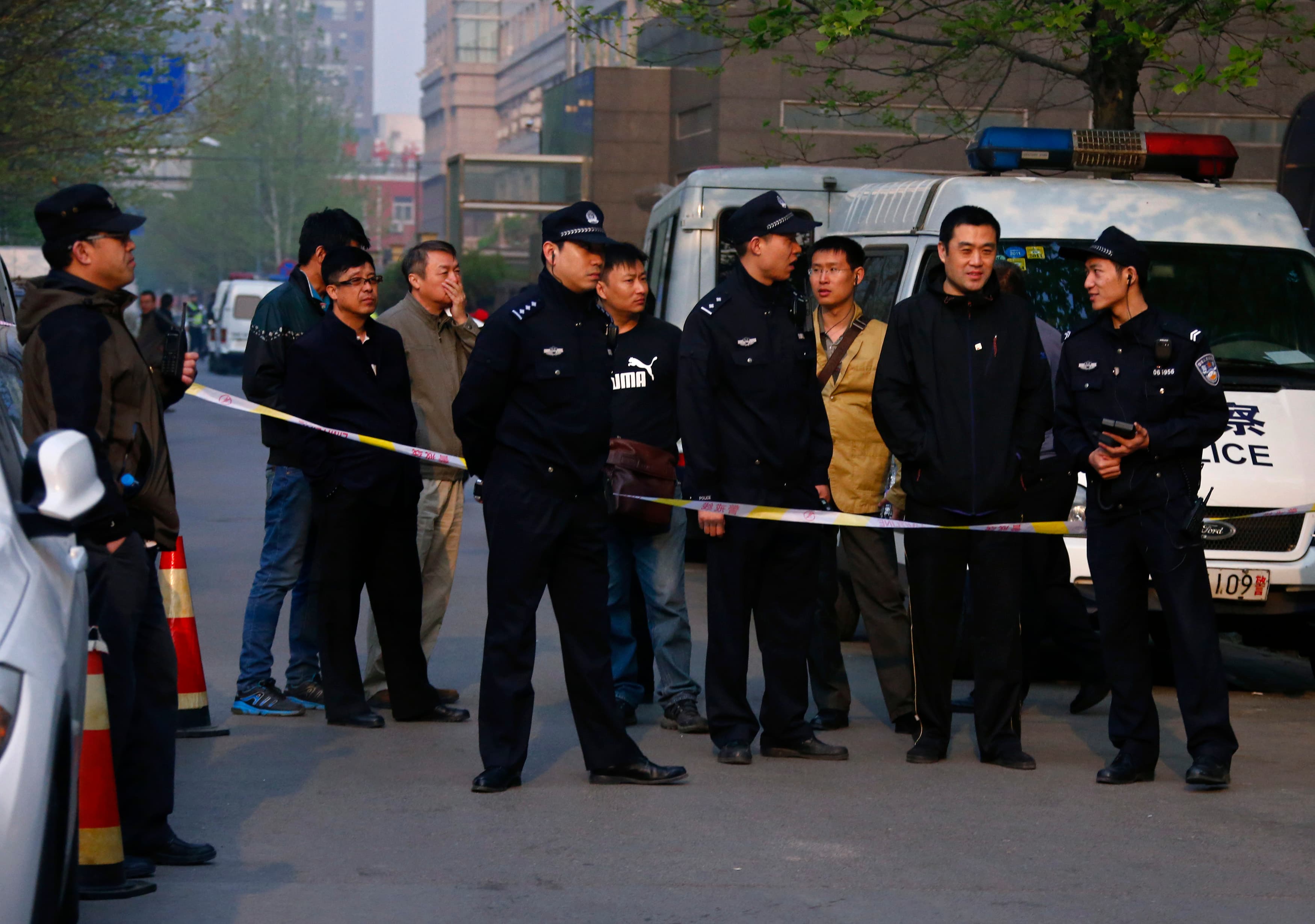 Police officers stand outside as Chinese human rights lawyer Ding Jiaxi stands trial at a court in Haidian District, Beijing, April 8, 2014.