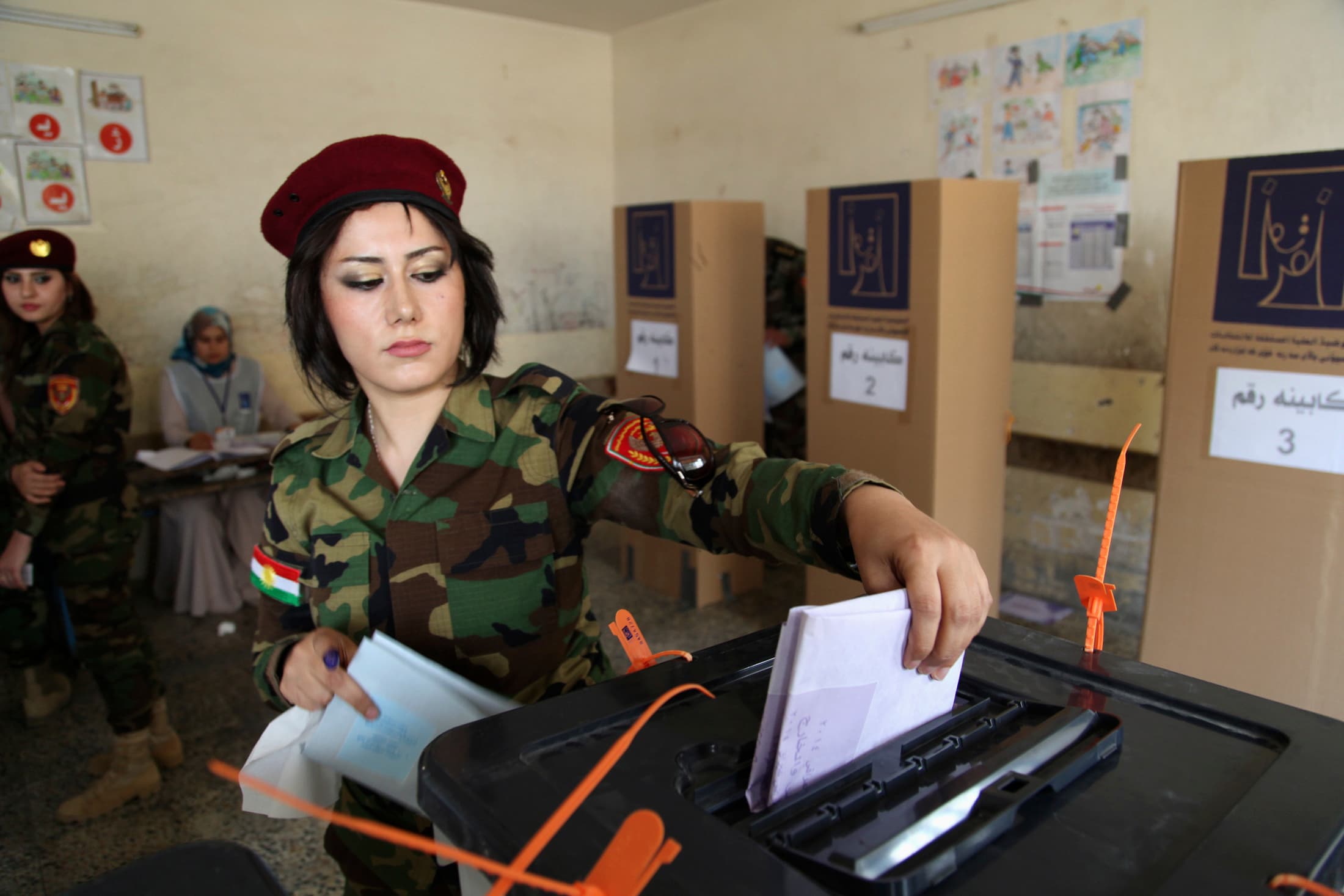 A member of Kurdish security forces casts her ballot inside a polling station during early voting for the parliamentary election in Irbil, in Iraq's Kurdistan region, on April 28, 2014.
