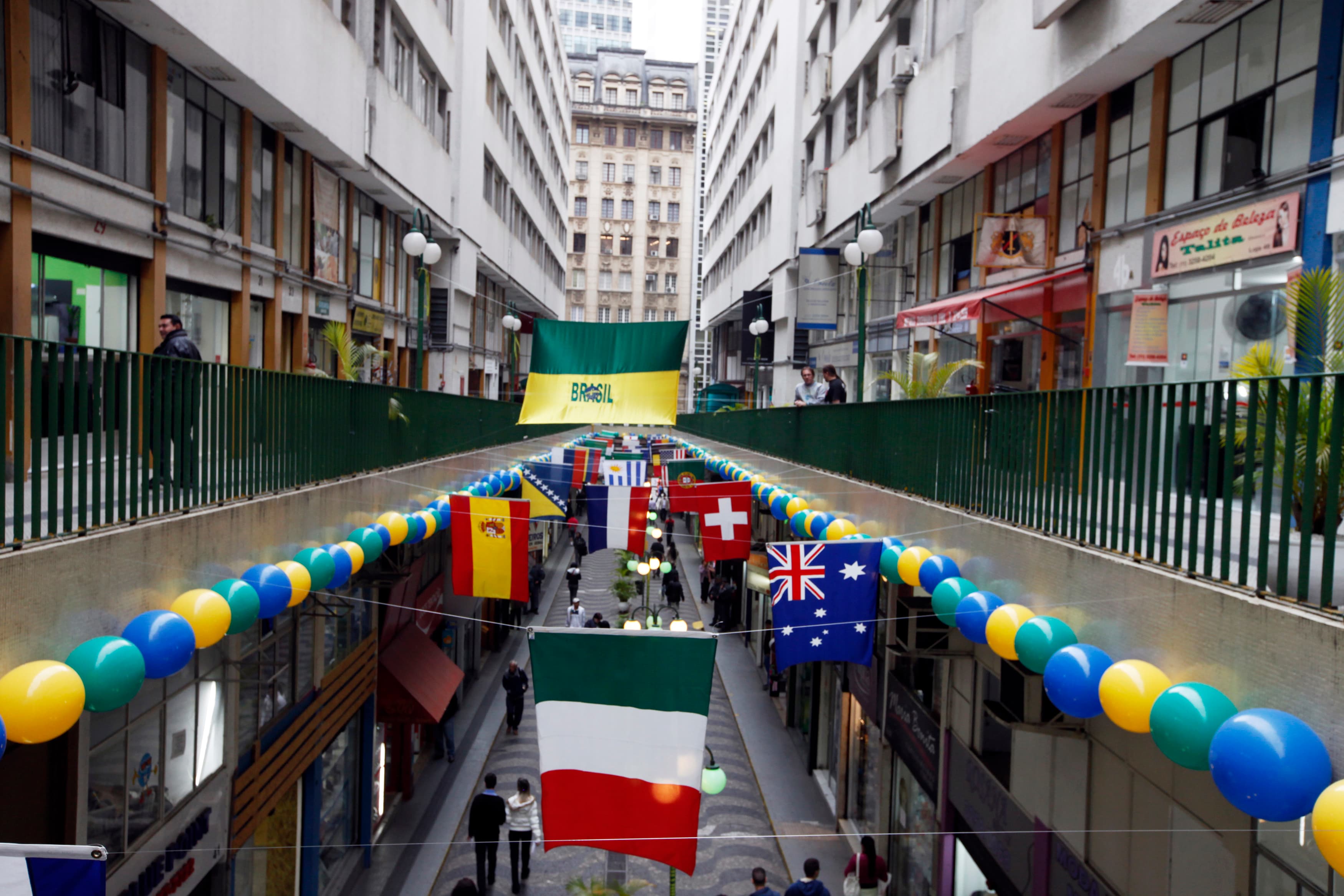 National flags of the countries that will participate in the 2014 World Cup decorate a commercial gallery in Sao Paulo.