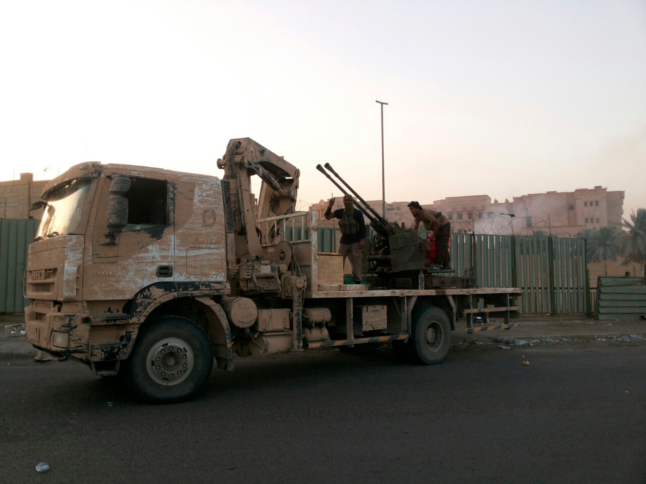 Fighters from ISIS on a vehicle in the Iraqi city of Tikrit, which the Sunni jihadi group overran on Wednesday, closing in on the biggest oil refinery in the country and making further gains in their rapid military advance against the Shi'ite-led governme